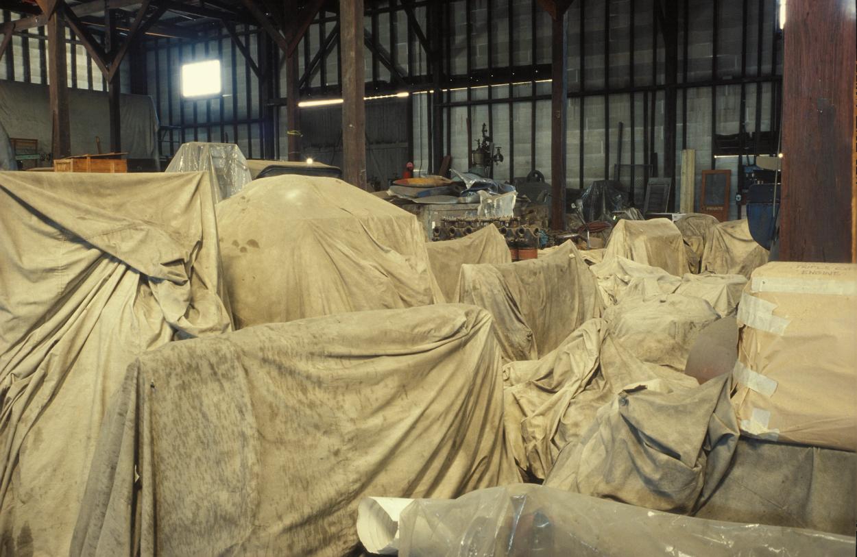 Colour photograph of museum objects in storage under canvas