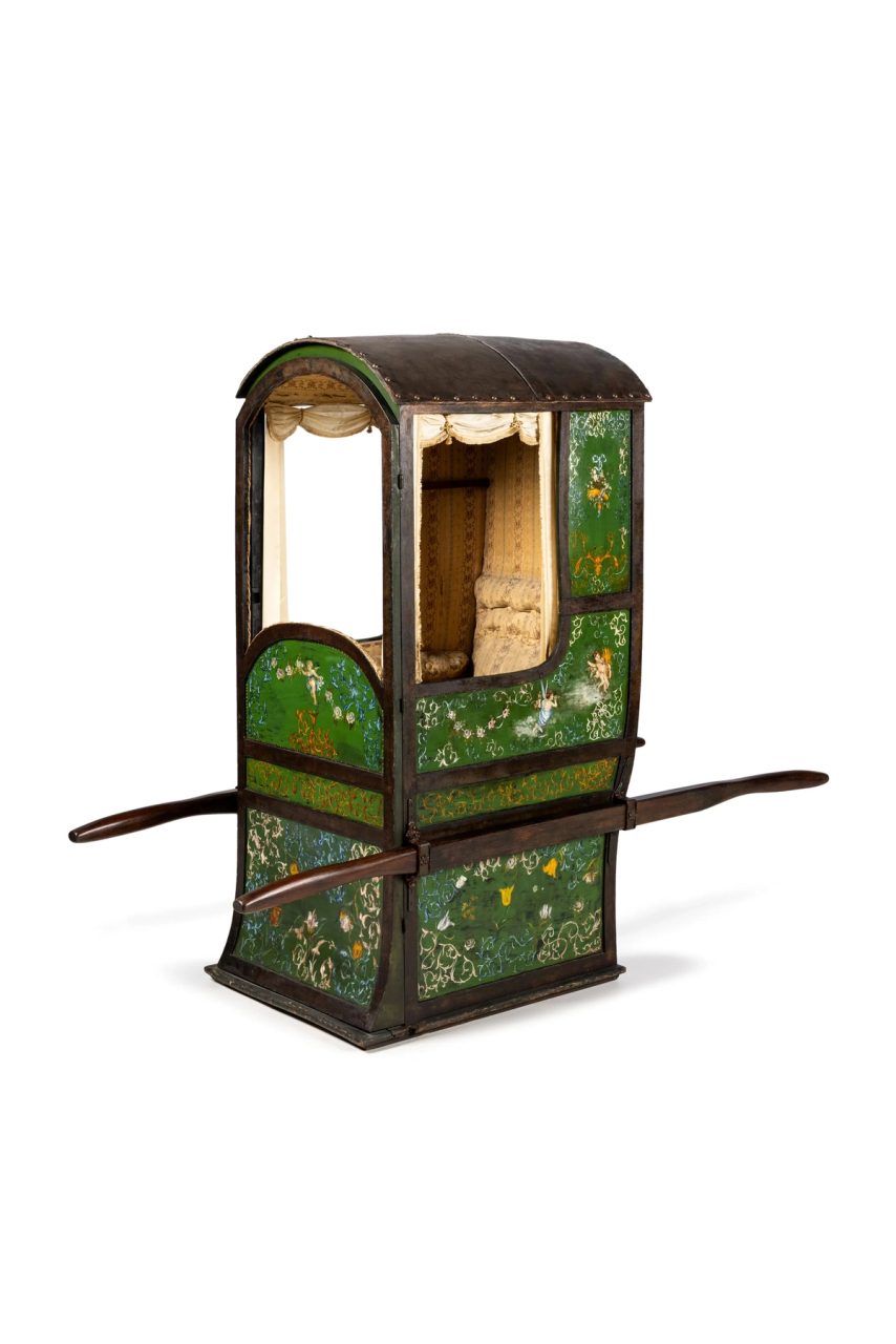 A green sedan chair with horizontal poles for carriers.
