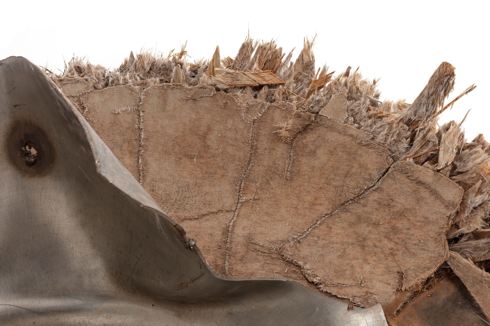 Space debris, Skylab space station, titanium/fibreglass, McDonnell Douglas Astronautics Co, USA, 1970-1972. The fragment is the end cap from pressurised oxygen tank from the Skylab space station. Originally the end of an enclosed cylinder, the titanium tank structure is torn and bent as a result of the stresses that ripped it away from the rest of the vessel. The exterior is covered by a composite insulation material with a woven fibreglass outer surface. A circular lid, protruding above the external insulation, covers an access hatch to the tank. A black and red wire, possibly originally connected to an external power source or sensor, is attached to the lid.