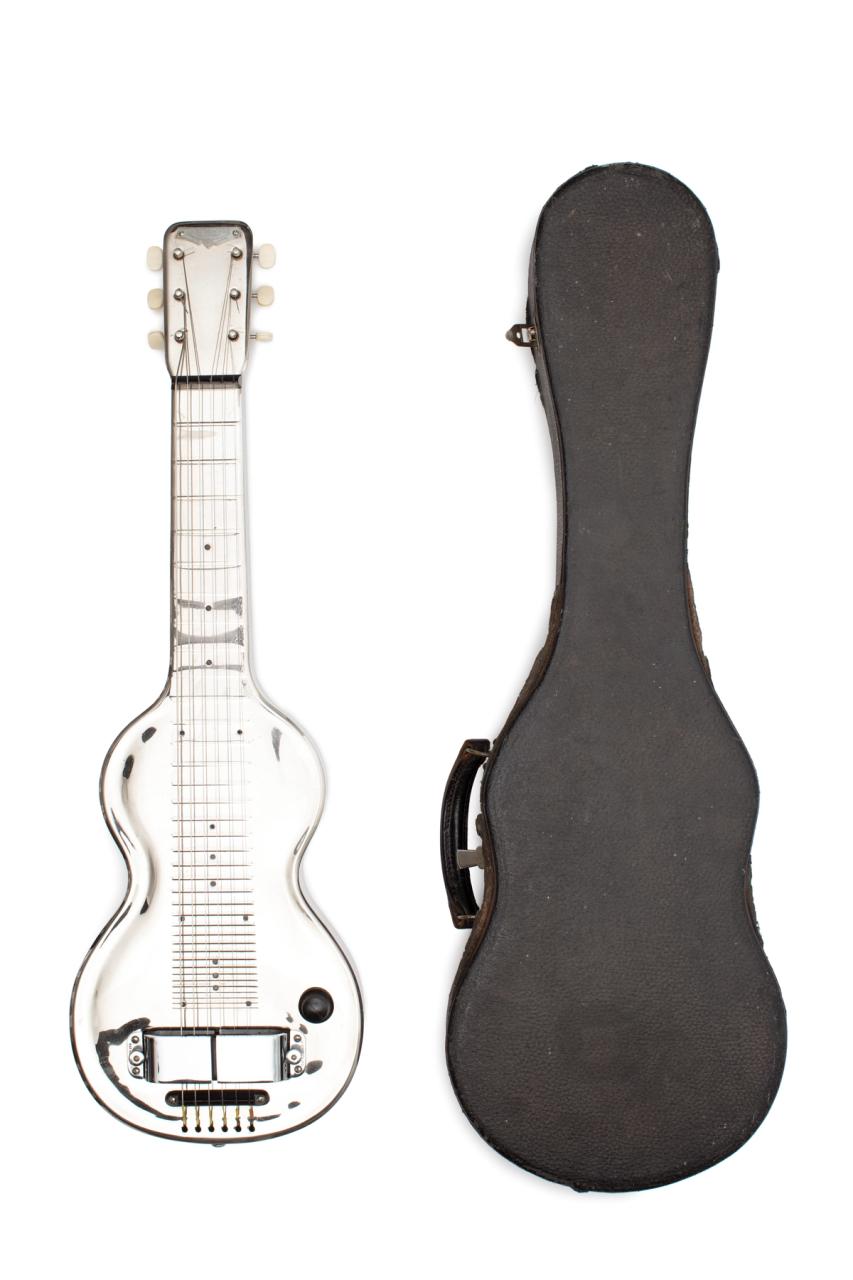 All metal body, Hawaiian style slide guitar, Bakelite pickups with magnetic coil; input jack at base; volume, control knob and tone adjustment by two screws beside the pick-ups; non-adjustable bridge; moulded frets.