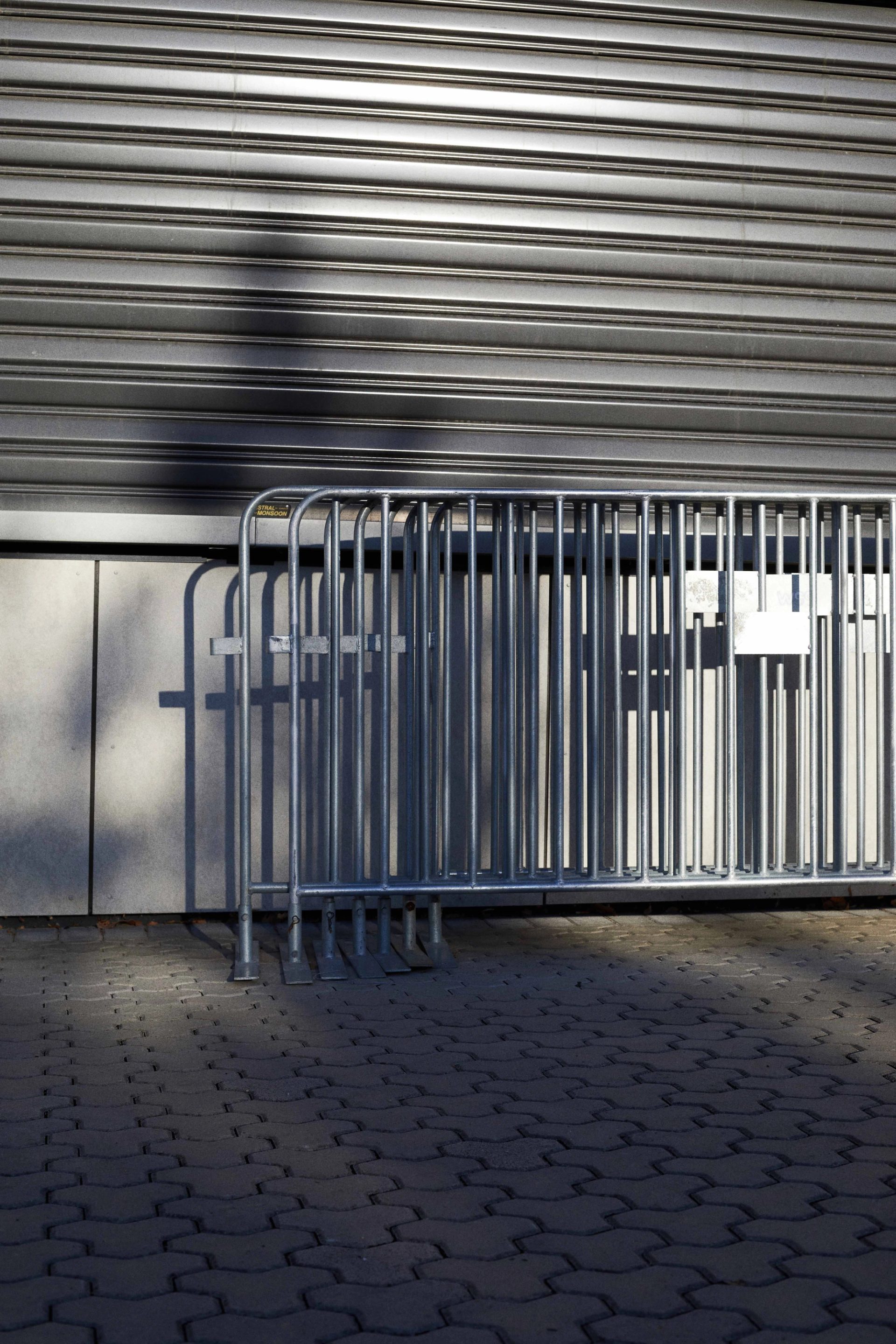 Silver fencing stacked together and leaning on a wall.