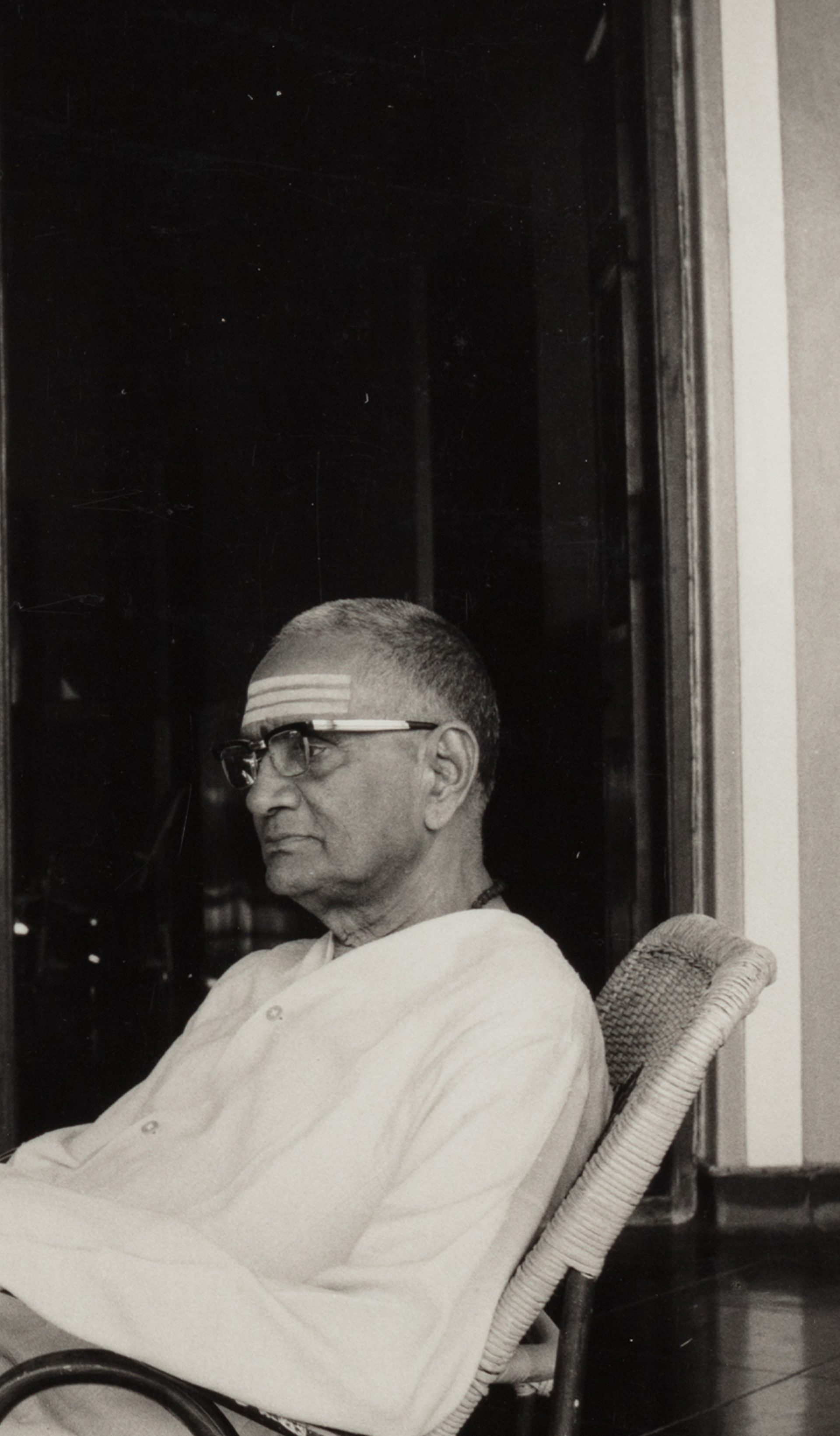 Black and white photograph depicting a woman (Subbulakshmi) wearing a sari looking down at a man (her husband T. Sadasivam) seated.