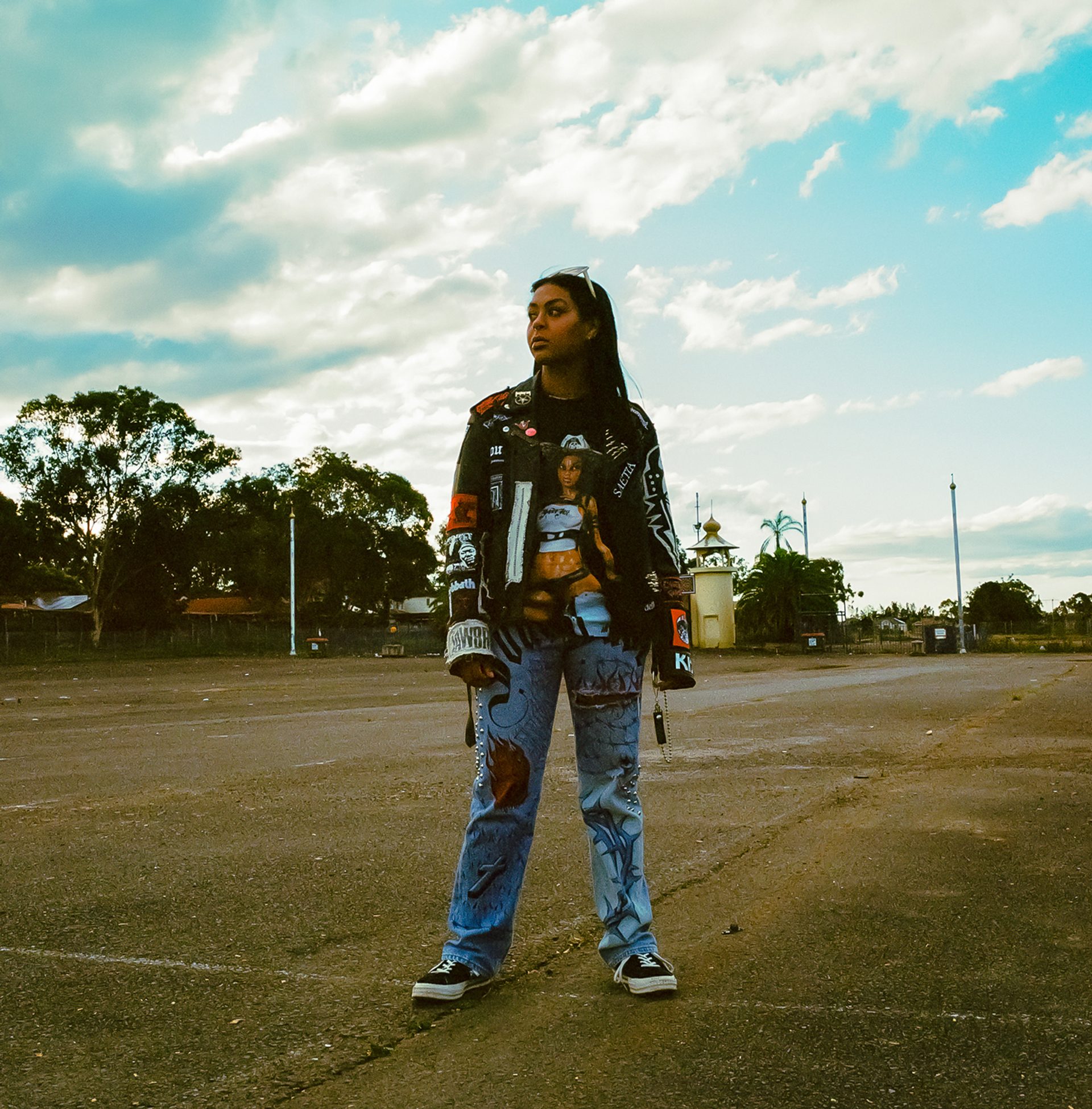 A young woman stands in an empty parking lot.