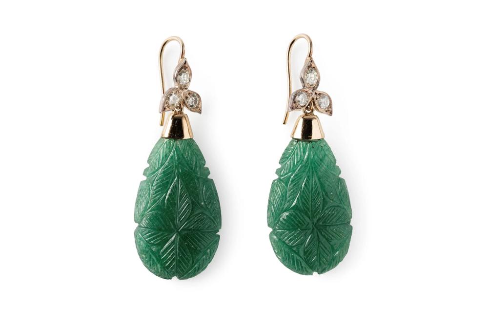 A pair of earrings in a teardrop shape. Made of emerald carved in a floral pattern with three diamonds atop each earring.
