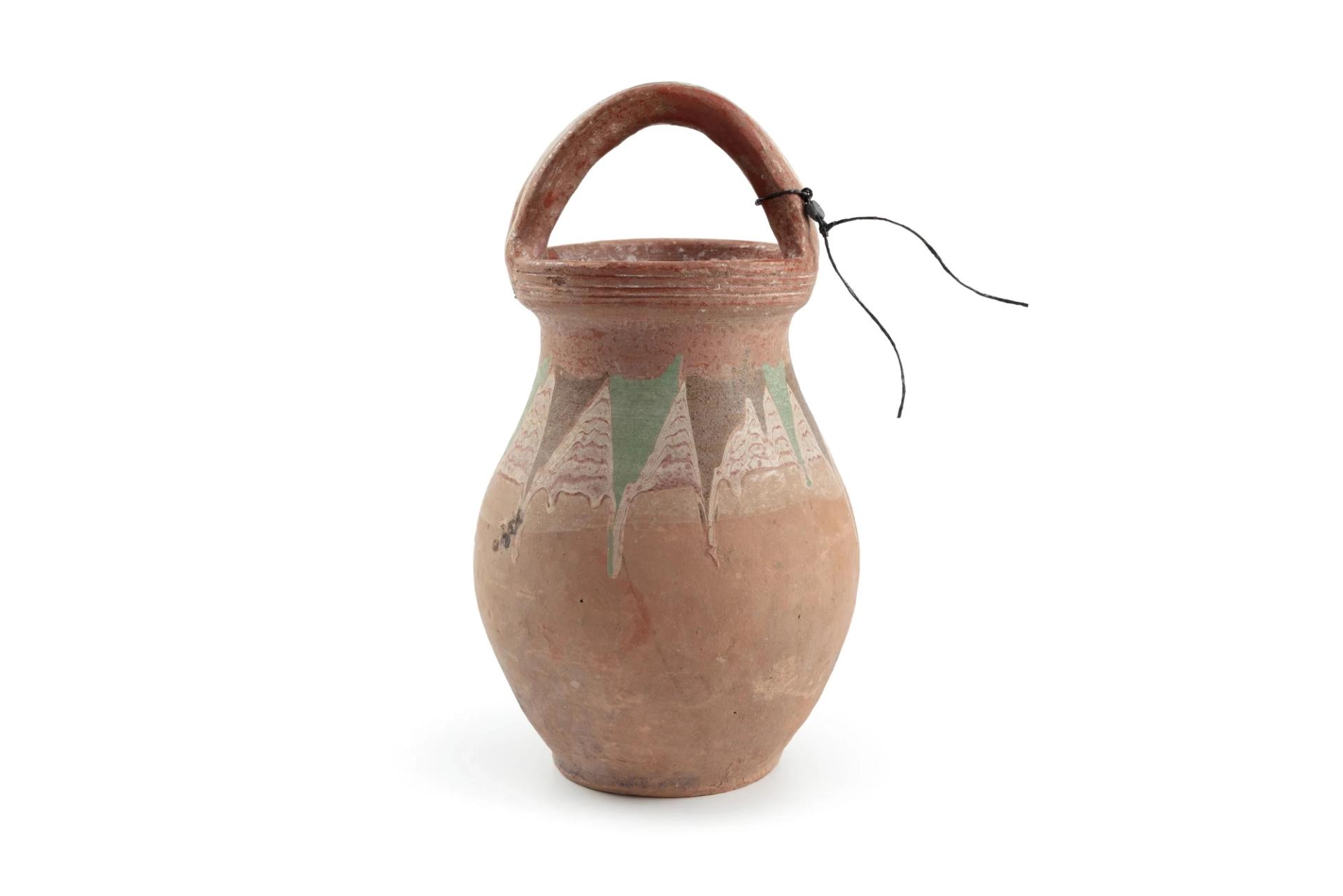 An earthenware yoghurt jar with the top half decorated with inverted triangles of alternating olive and light green on a white combed ground.