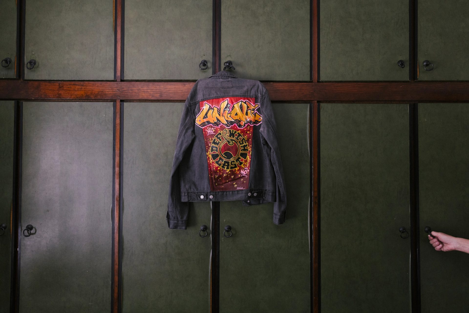 Denim spray jacket that says 'Unique' and 'Def Wish Cast'