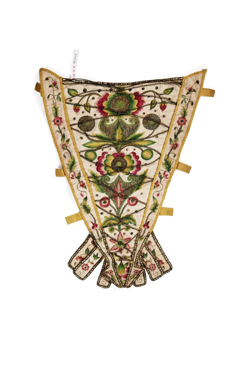 Inverted triangular silk panel for the front of a corset embroidered with green, red and yellow flower patterns.