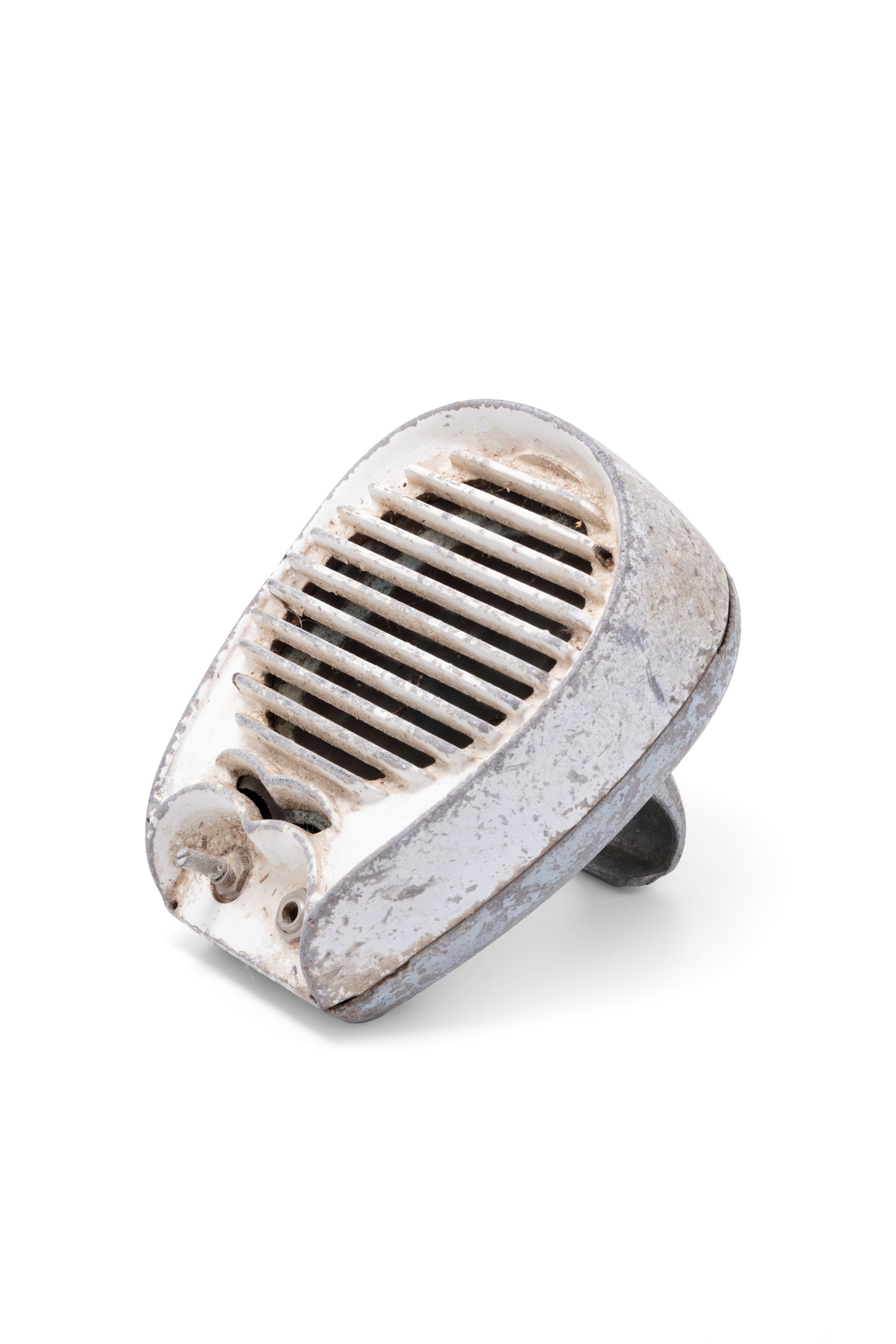 Metal casing painted cream, the casing has rounded edges and a circular grill at the front to allow sound to escape.