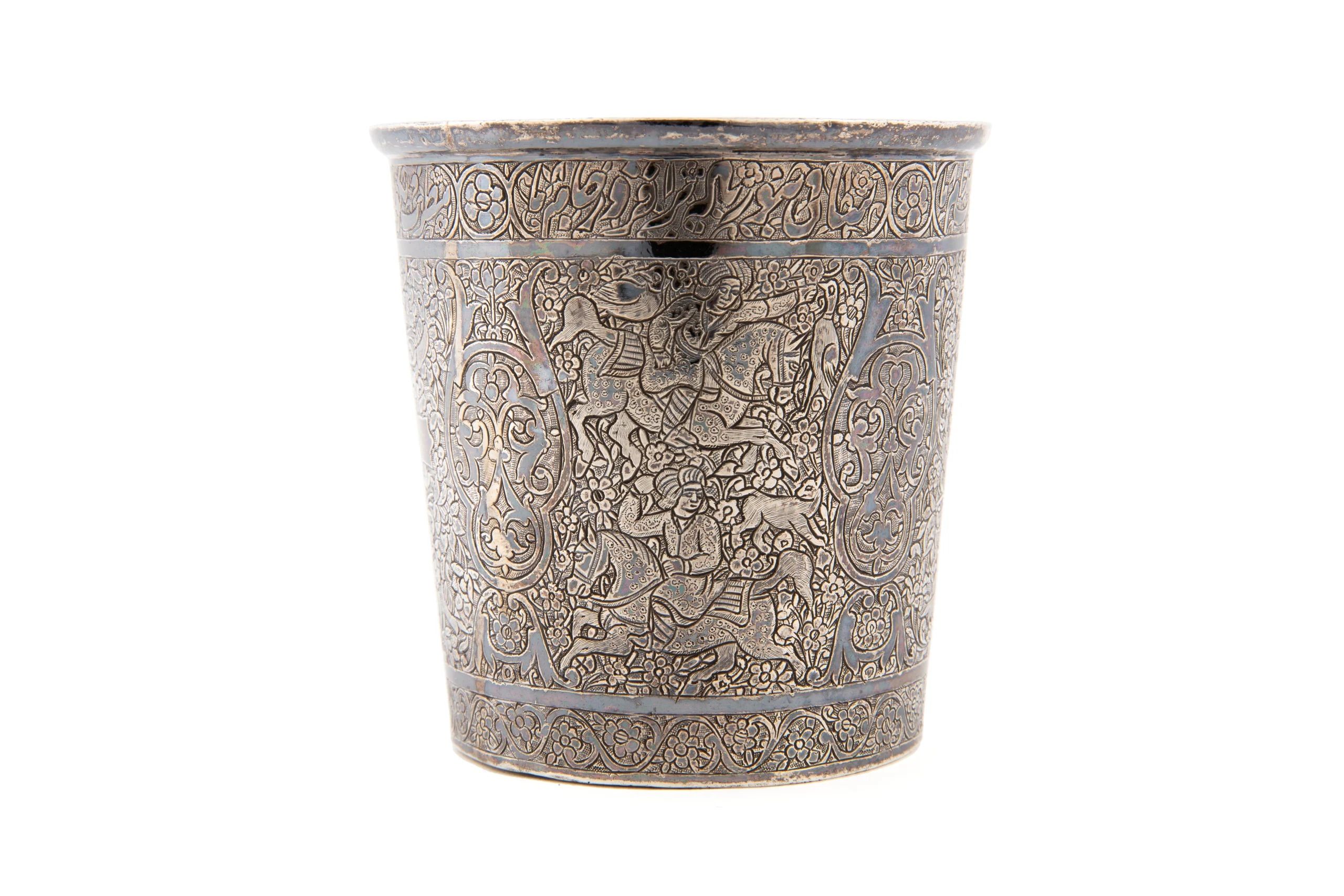 A silver wine beaker decorated with engraved human, animal, and floral motifs.