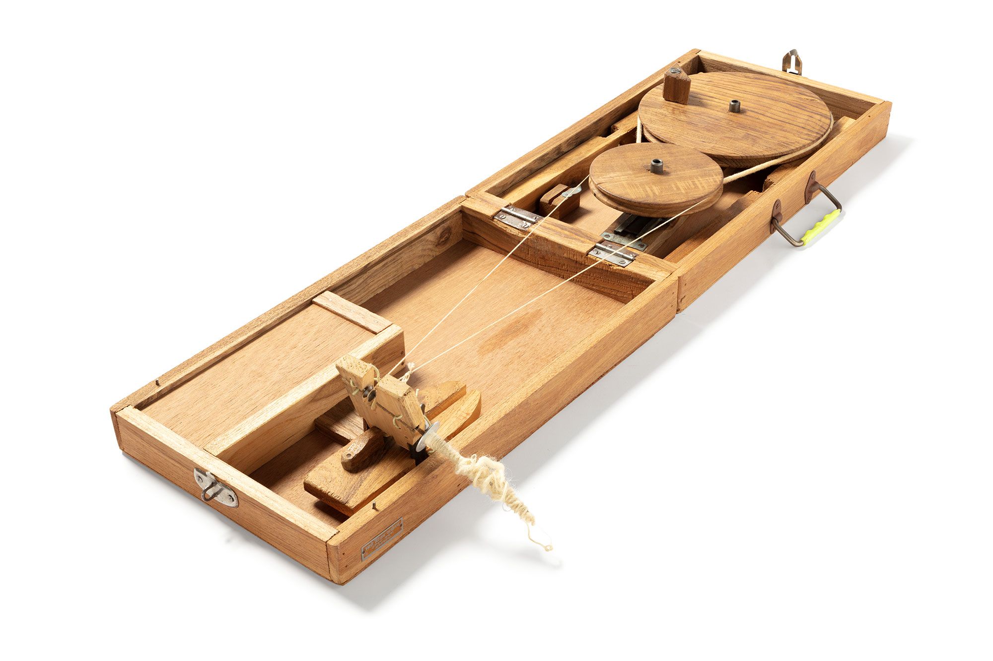 Rectangular shaped wooden carry box with two metal hinges and a metal lock fitting and metal and plastic handle. Inside the box two discs are threaded onto metal upright rods that are attached to a wooden length on the base of the box. The discs rotate in a horizontal plane.