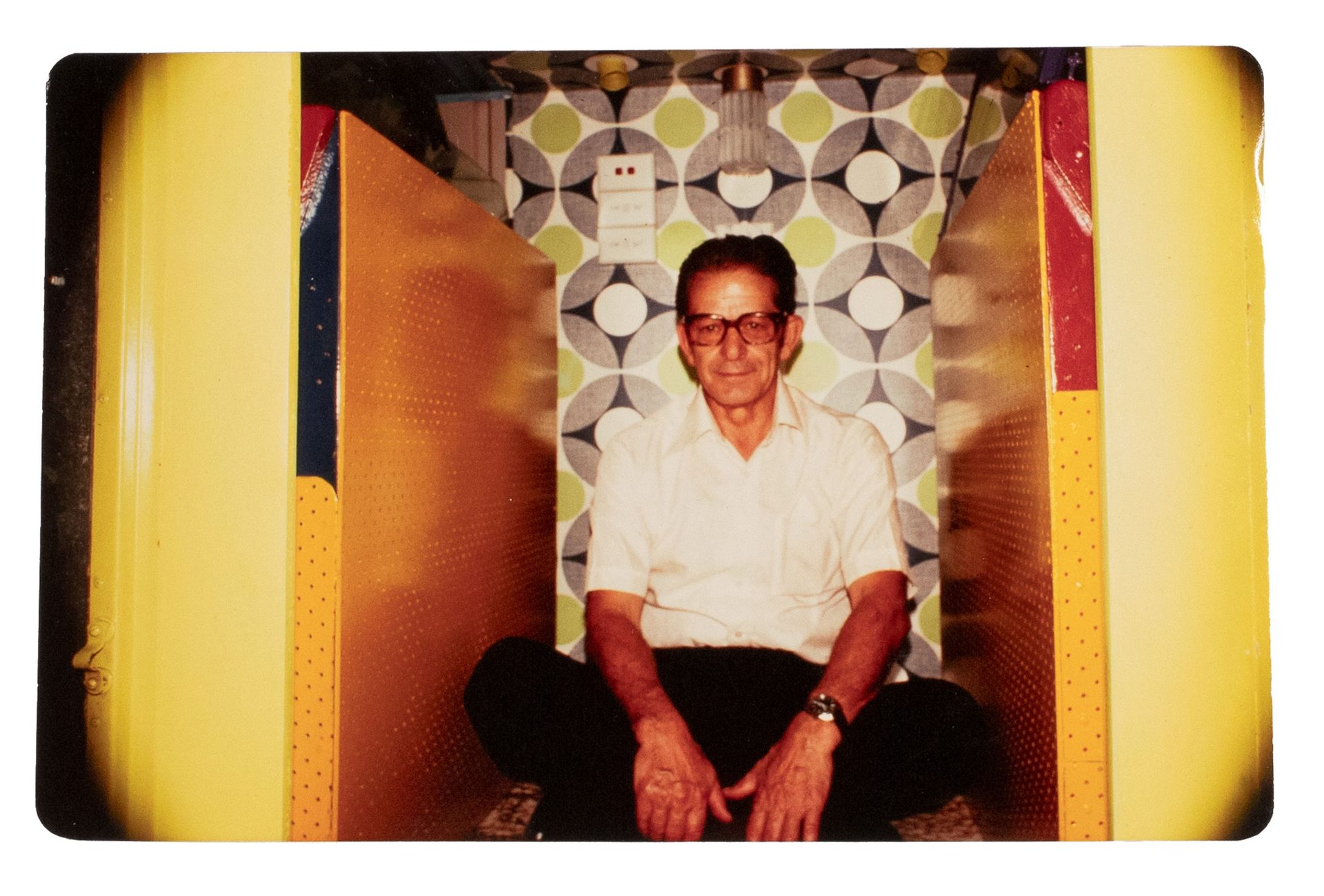 A man in white shirt sitting in between two oscillator machines