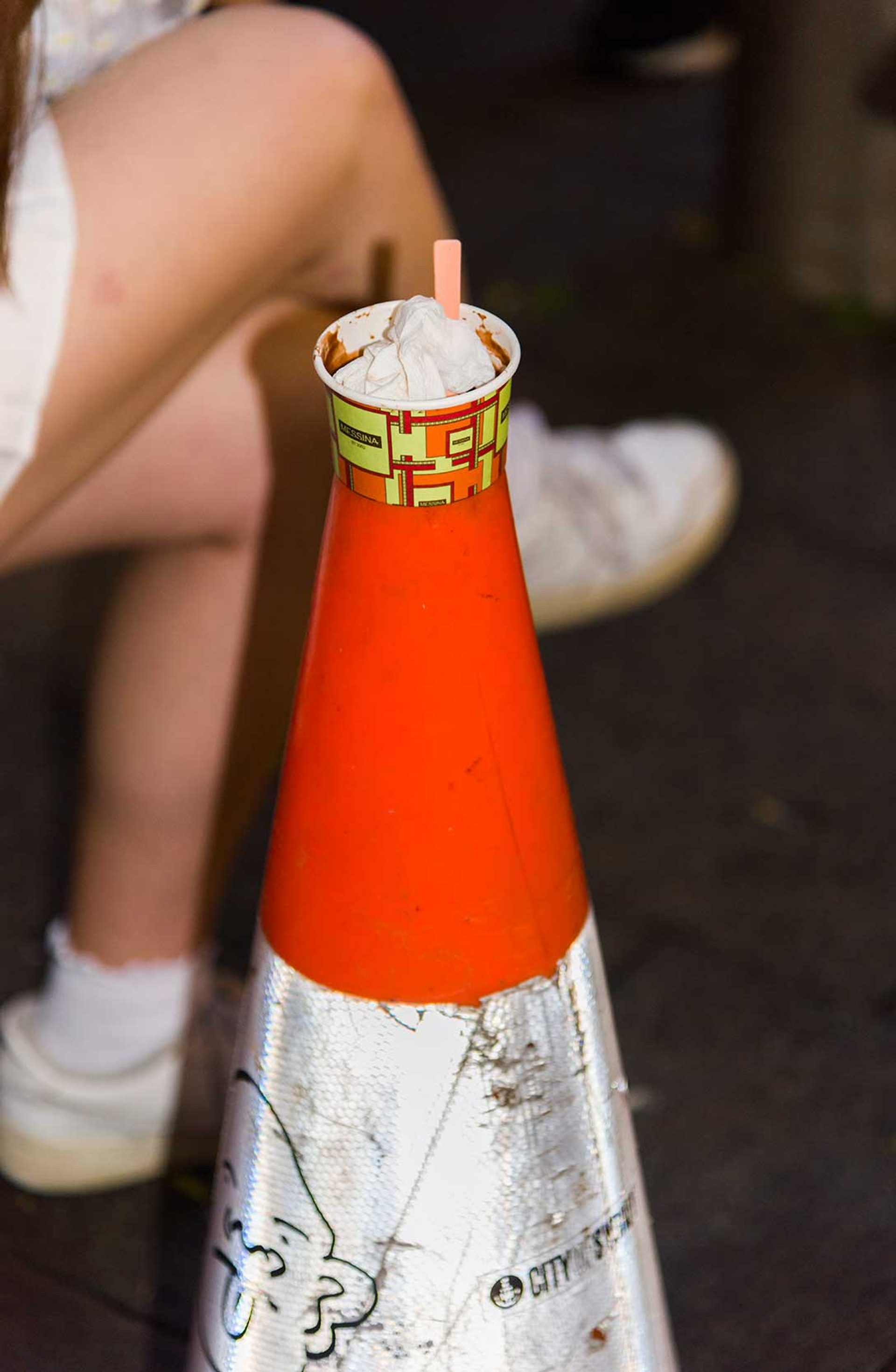 A tissue inside a Messina ice cream cup, the Messina cup is inside the top of a traffic cone.