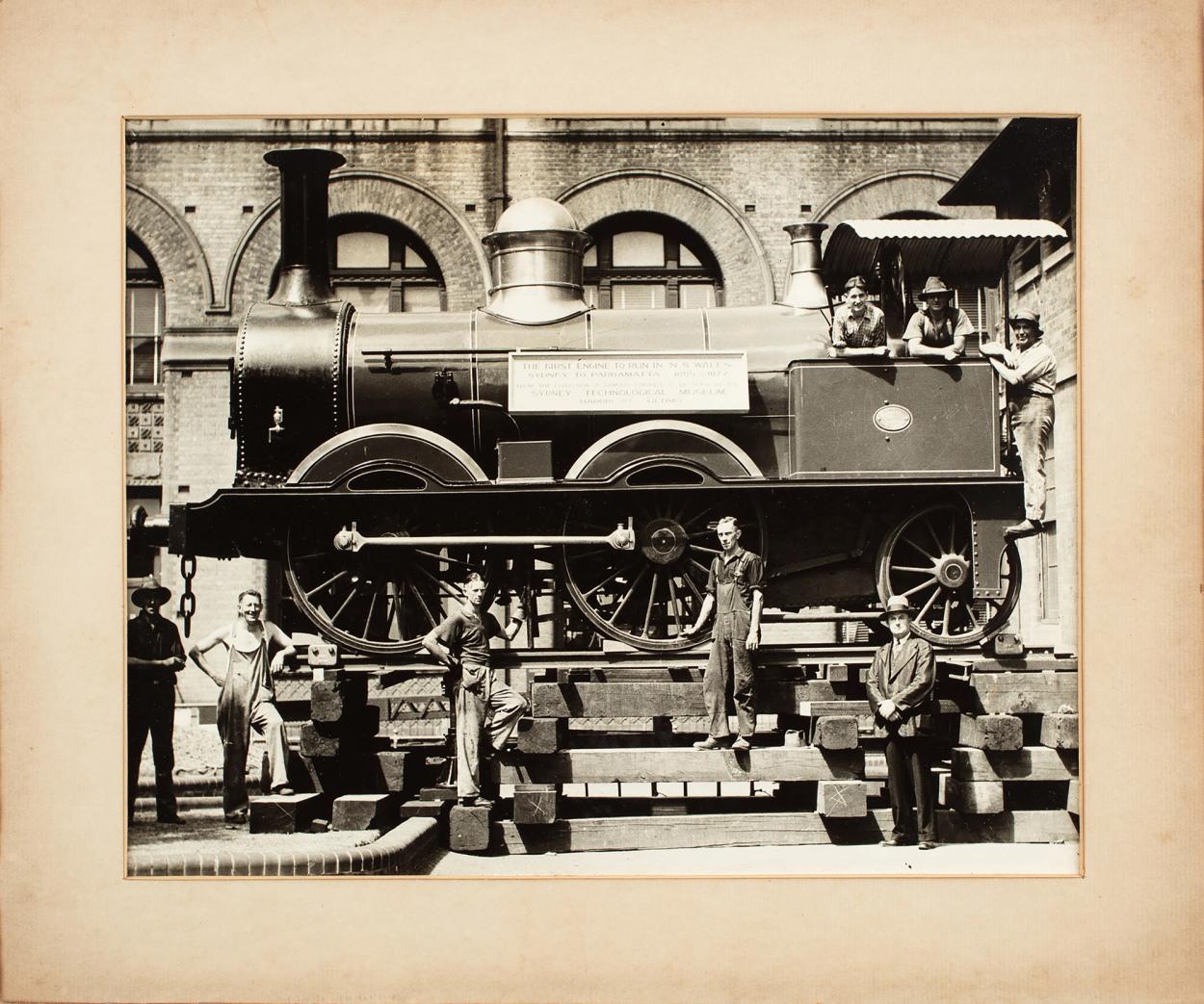 Archival photograph of a men moving a large steam train