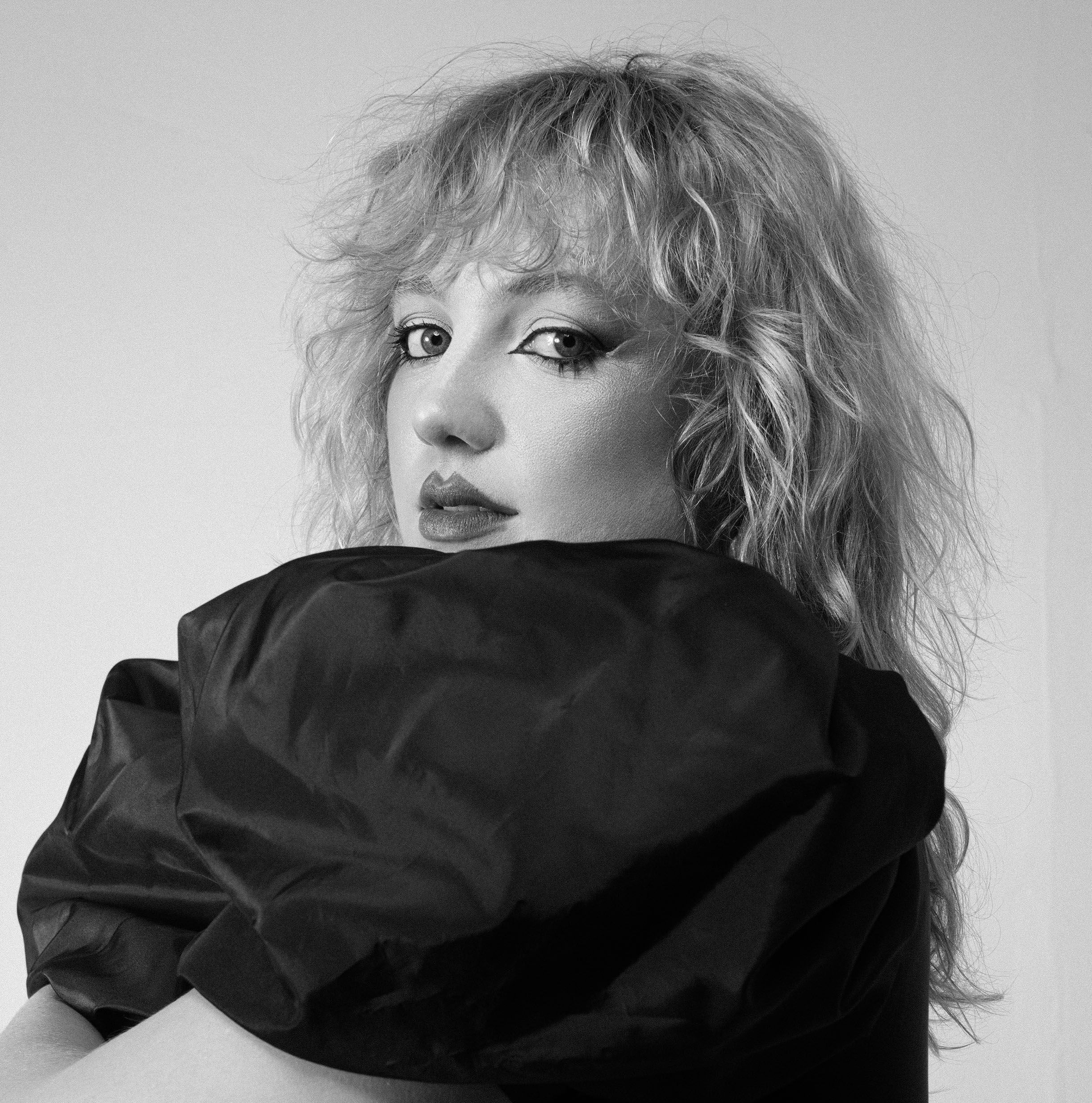 Figure holding their body wearing makeup.