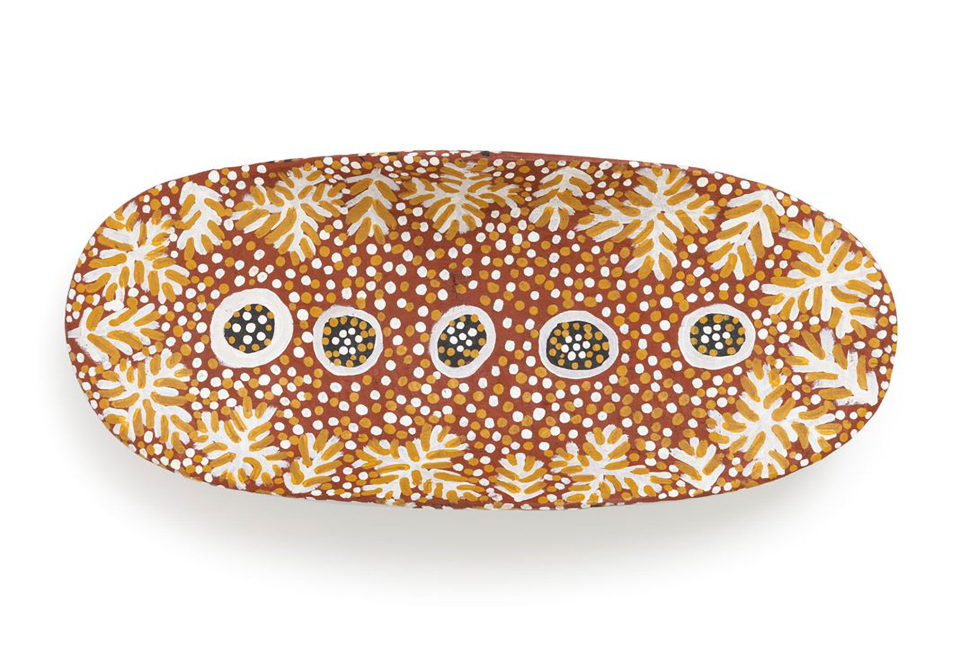 Coolamon, wood, carved from tree trunk, oval shape, curved base with sides along longest axis higher than ends, covered in acrylic paint, terracotta background all over with designs on inside and outside added representing the traditional Bush Tomato Dreaming. On inside are five black circles down centre with white outline and white and ochre dots, foliage pattern around edge, between which are white and ochre dots.