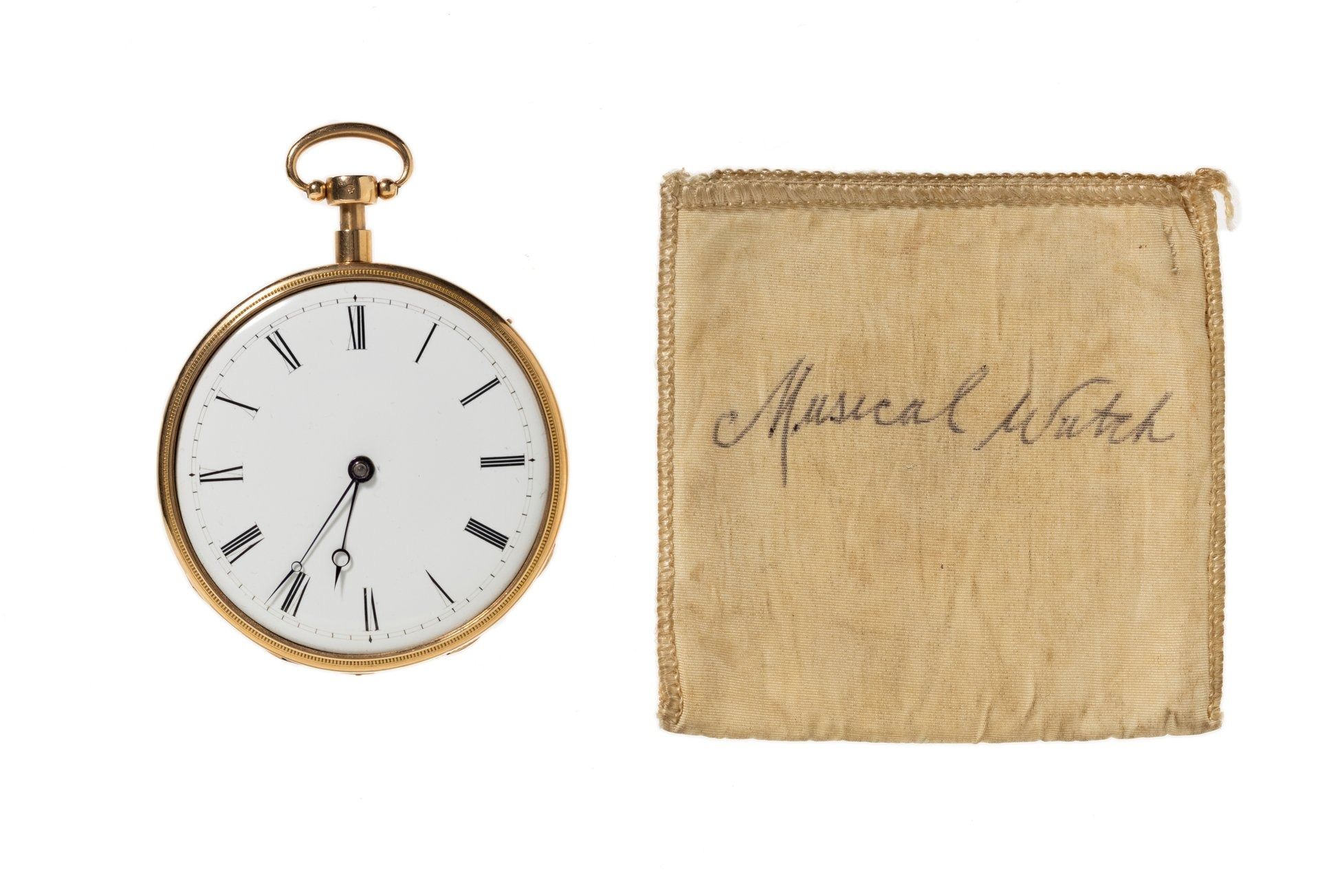A gold rose pocket watch with the hands showing the time as 6.37 and a cloth pouch with handwriting: 'Musical Watch'.