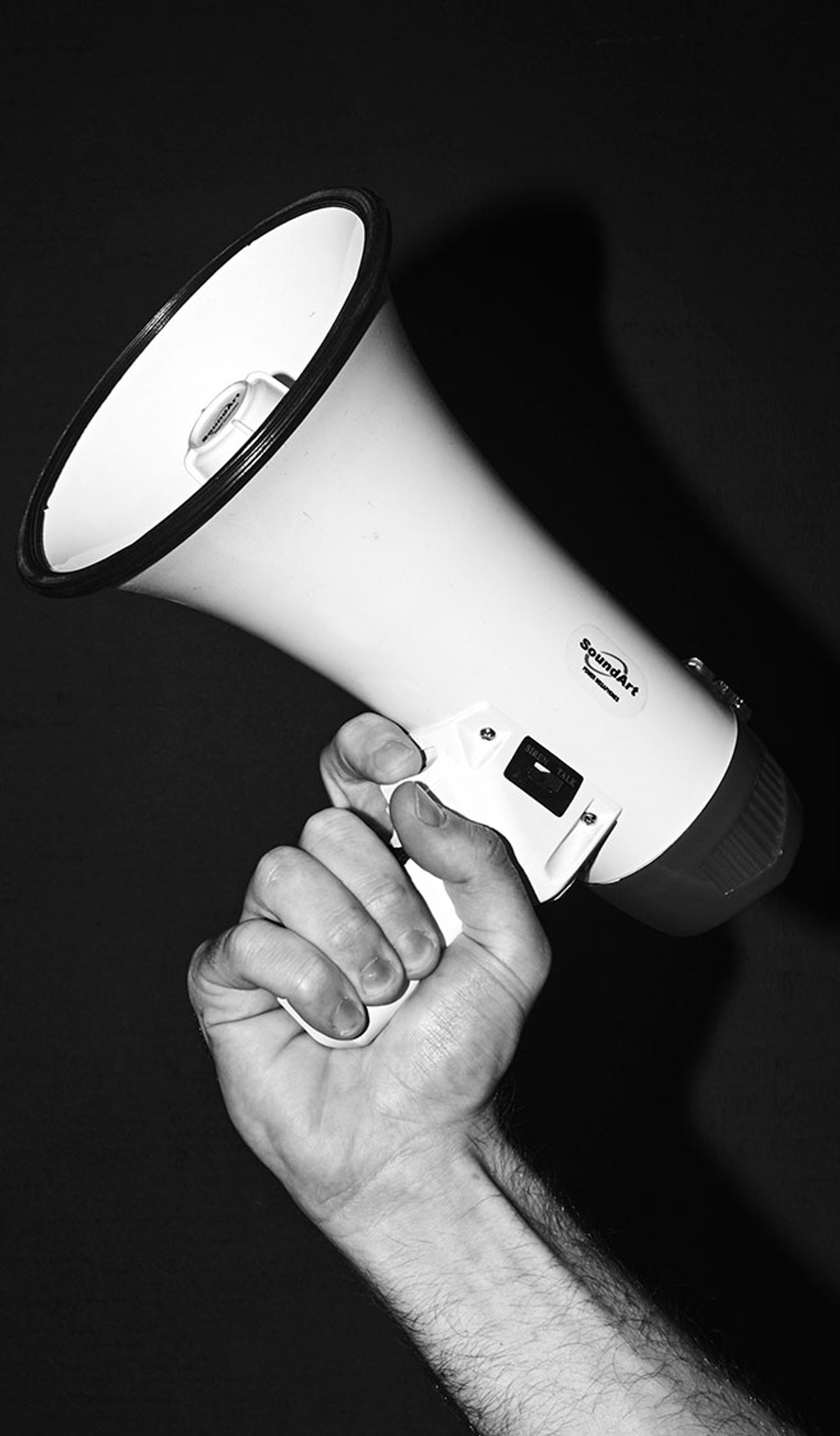Black and white image of a hand holding a megaphone