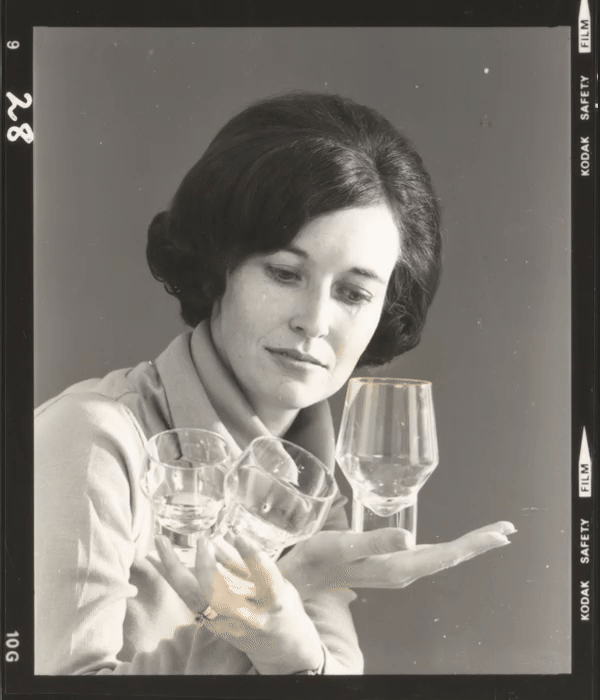 A motion image flicking through black and white film photo cells of a woman (Denise Larcombe) holding multiple glassware.