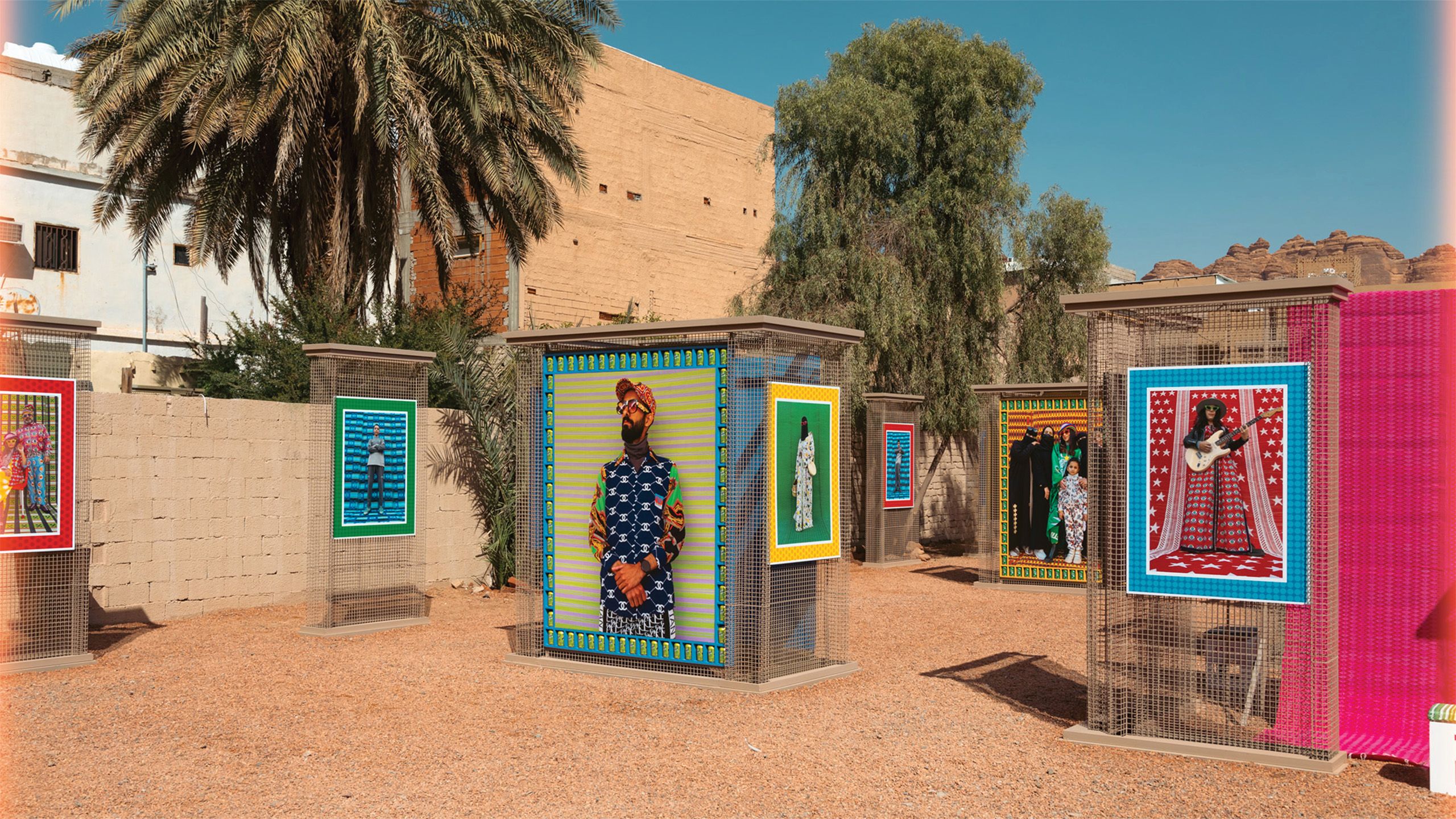 Outdoor exhibition of pillars with framed artworks atop them.