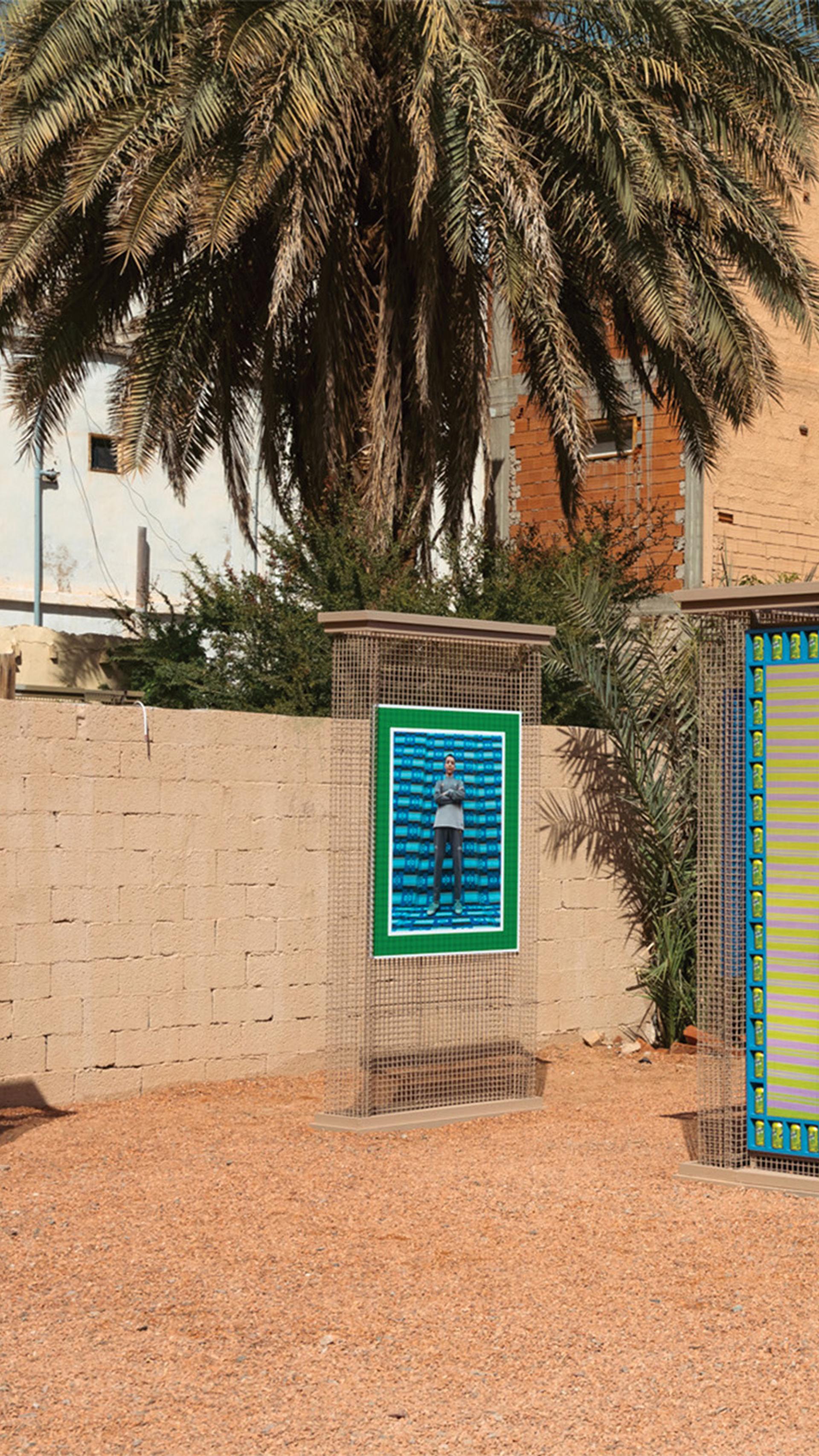 Outdoor exhibition of pillars with framed artworks atop them.