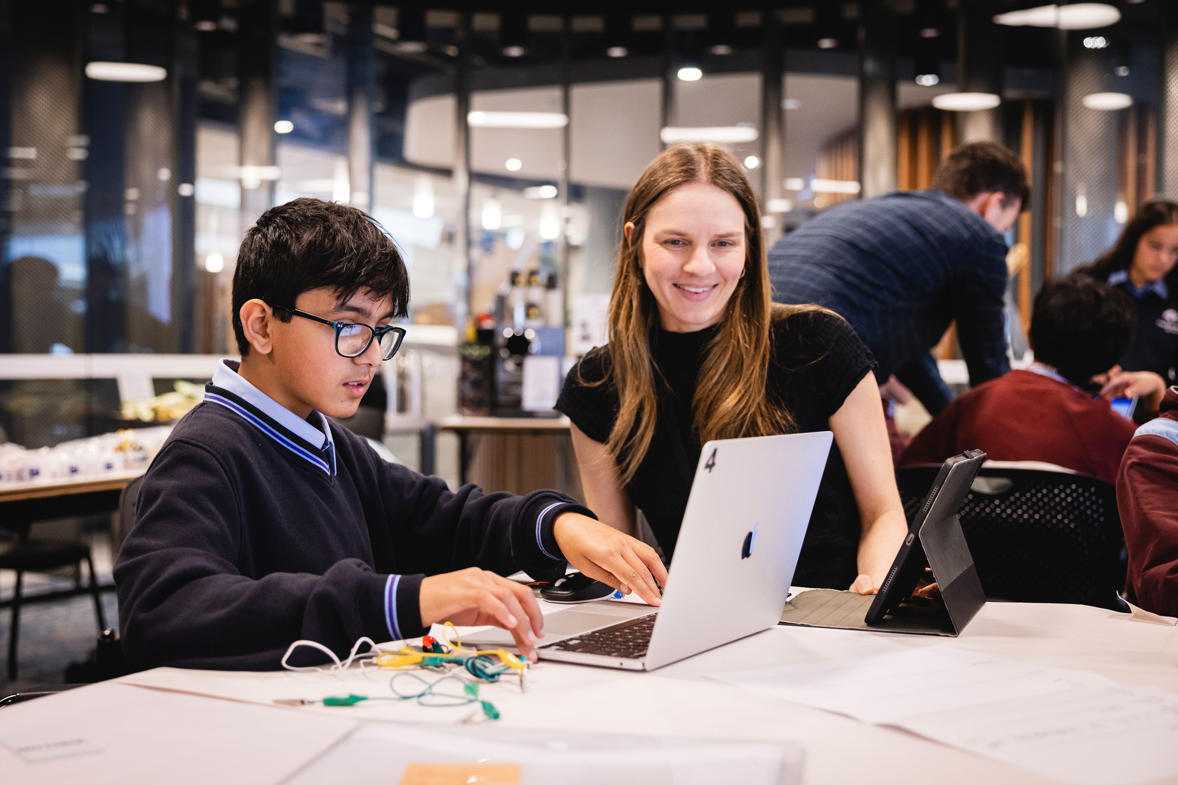 Photo of a student and teacher working together on a laptop.