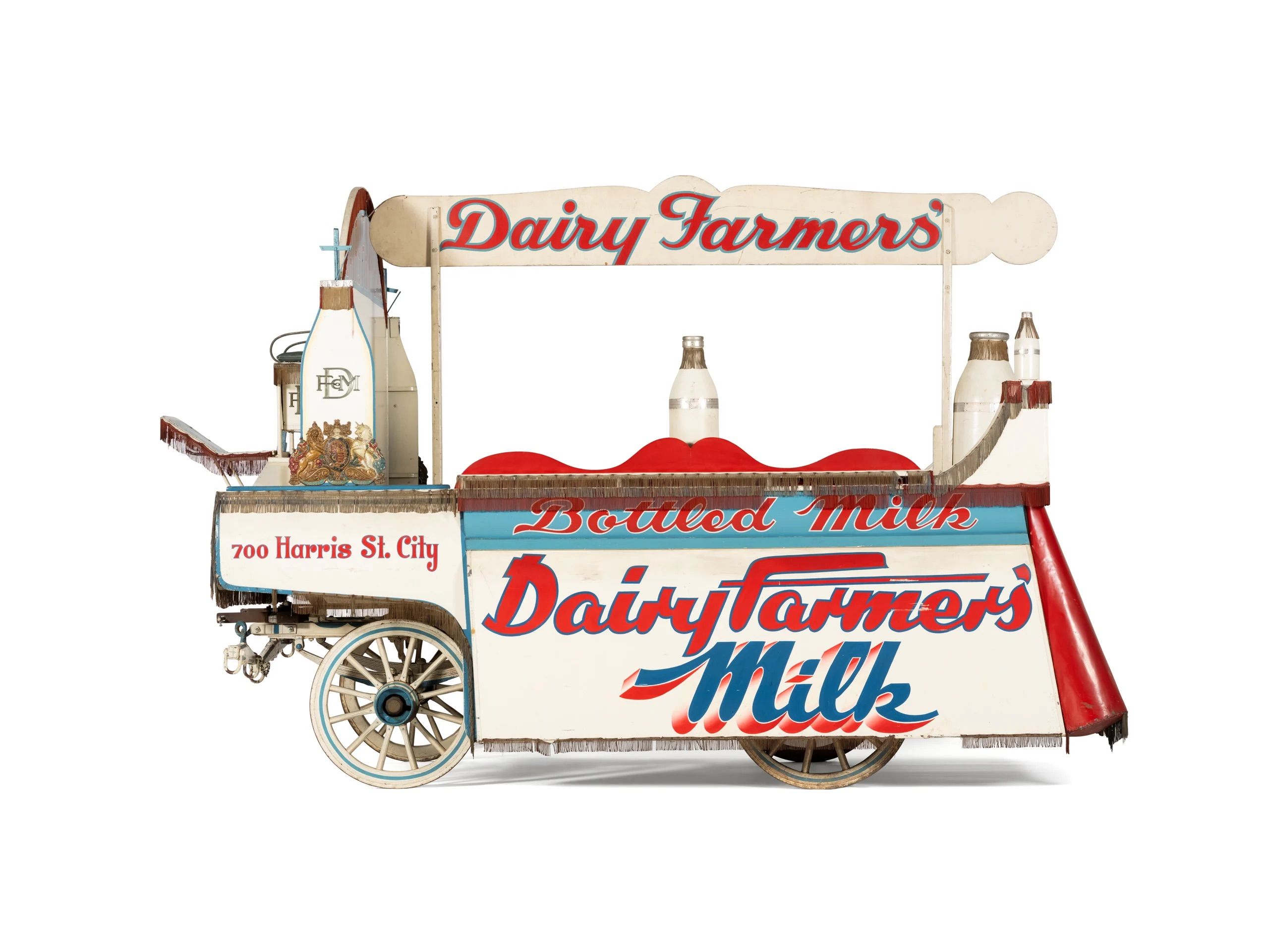 A wooden wagon painted white with blue and red decorative text.