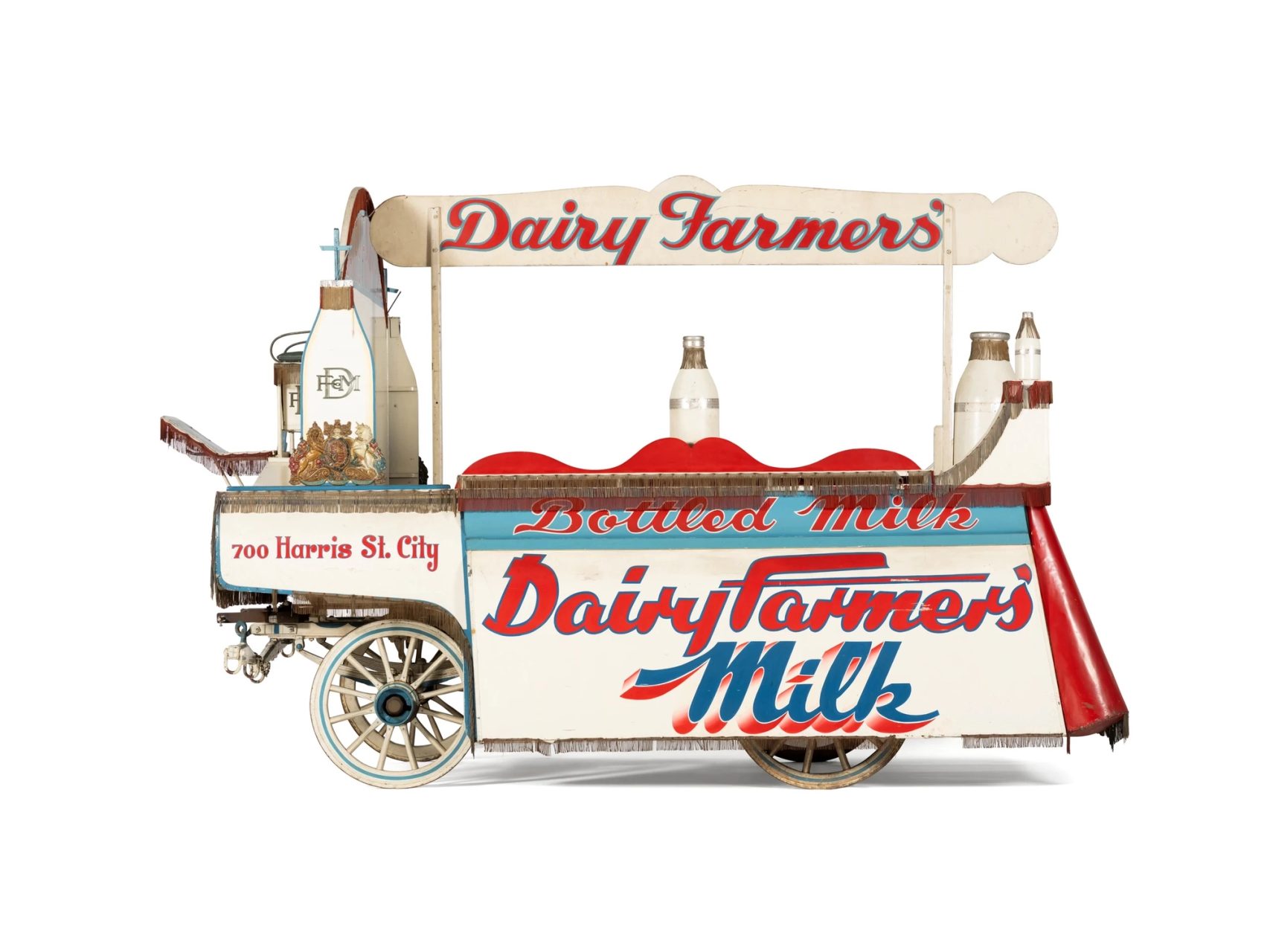 A wooden wagon painted white with blue and red decorative text.