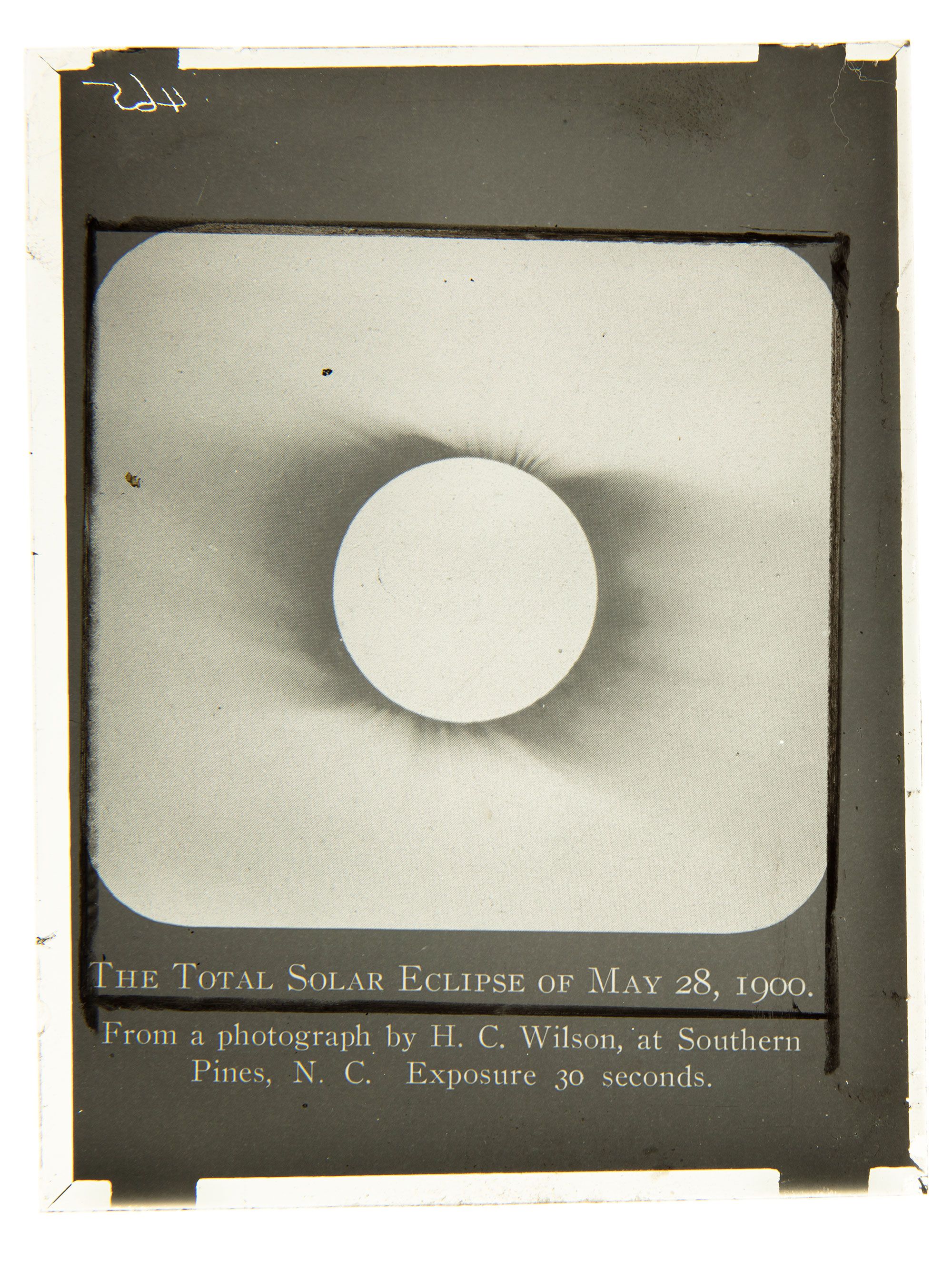A black and white glass plate slide that depicts a solar eclipse.