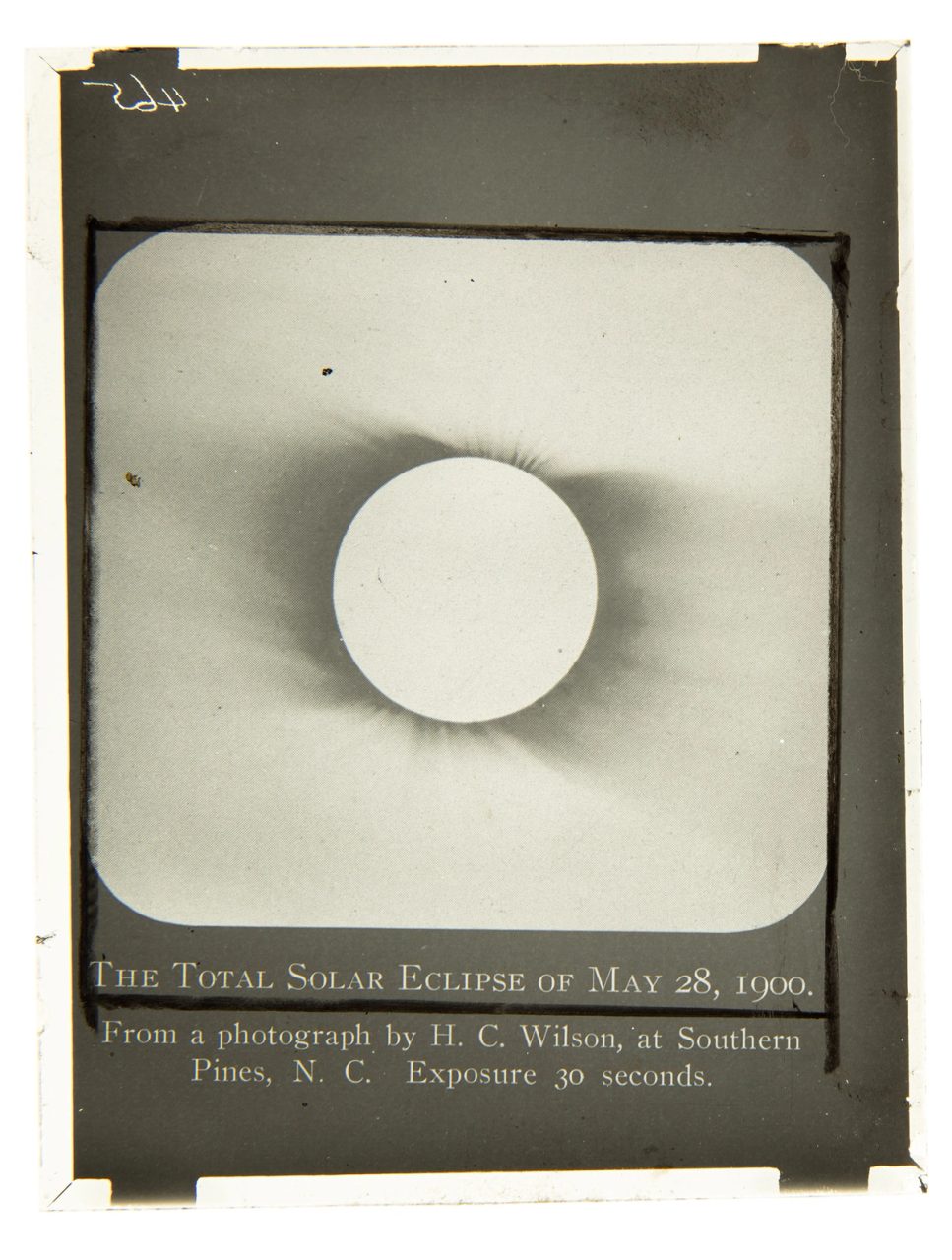 A black and white glass plate slide that depicts a solar eclipse.