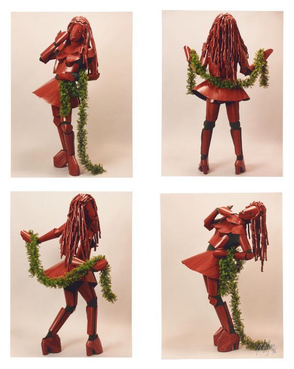 Four photographic prints of Brenton Heath-Kerr in his Woodwoman costume in various poses complete with plastic ivy boa and imitation woodgrain ringlets.