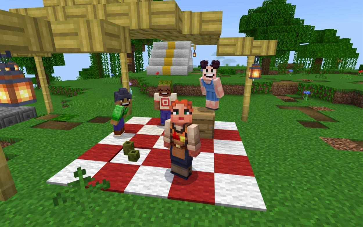 Four Minecraft characters are positioned around a picnic rug in a Minecraft forest.