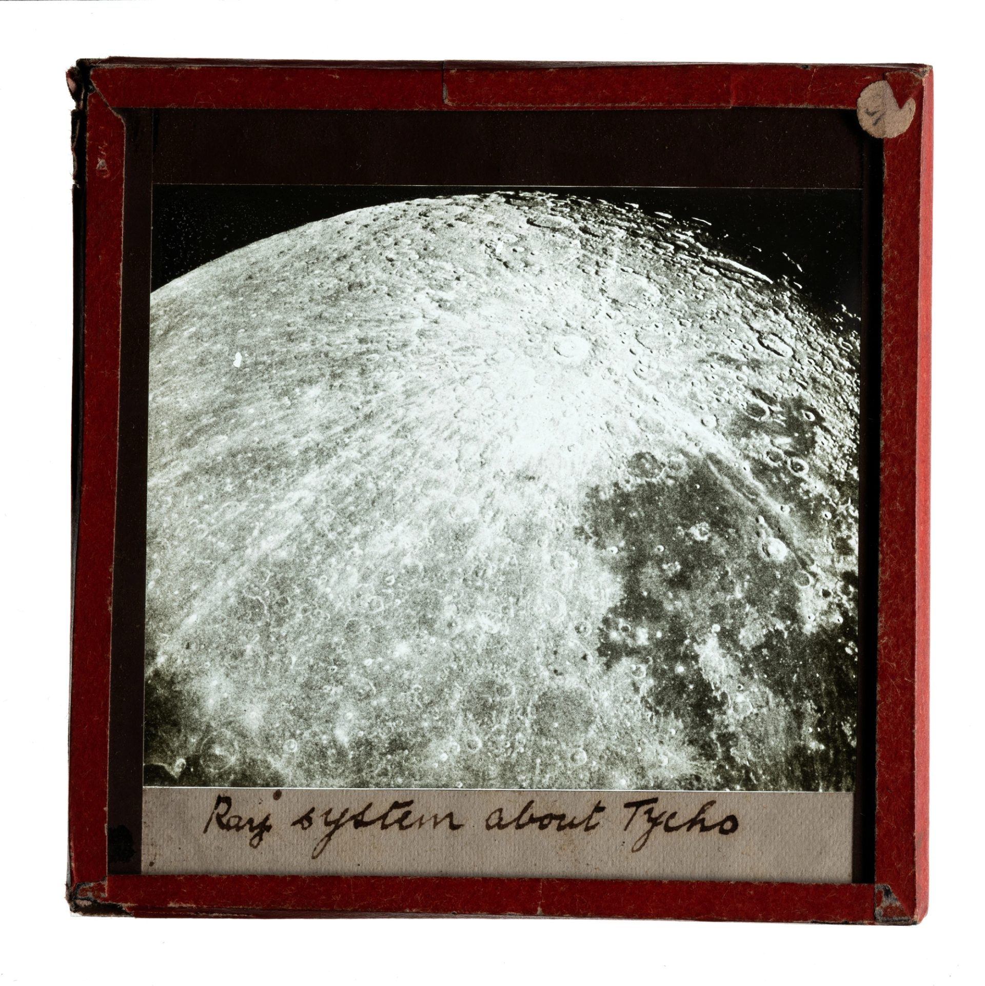 A glass plate slide with a red frame, showing the ray system around Tycho.