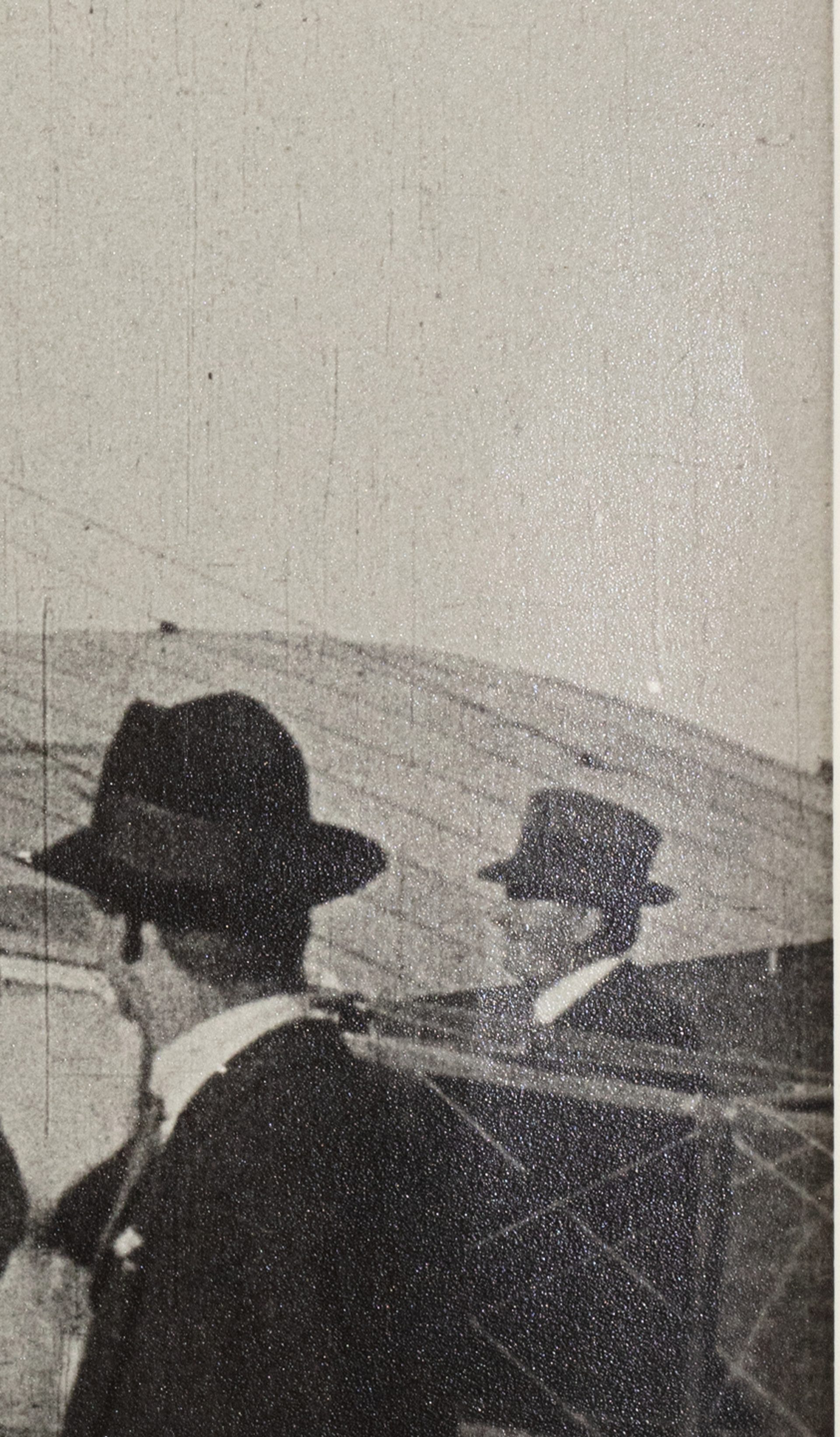 Black and white photograph of the first Australian airmail flight at Government House Melbourne. Multiple men in suits and hats looking to a pilot sitting on a plane, preparing to fly.
