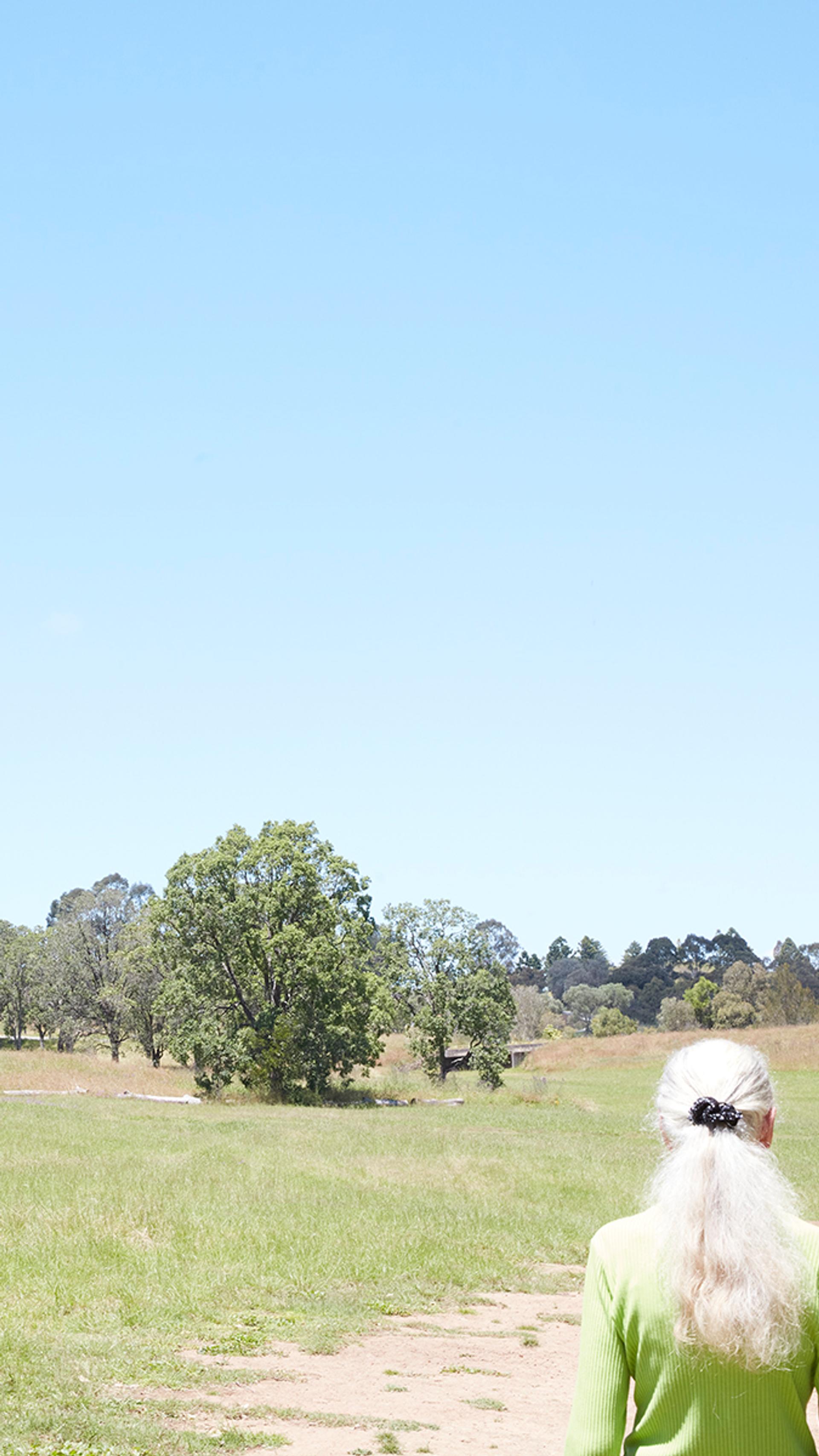 A white haired lady roams amongst the countryside.