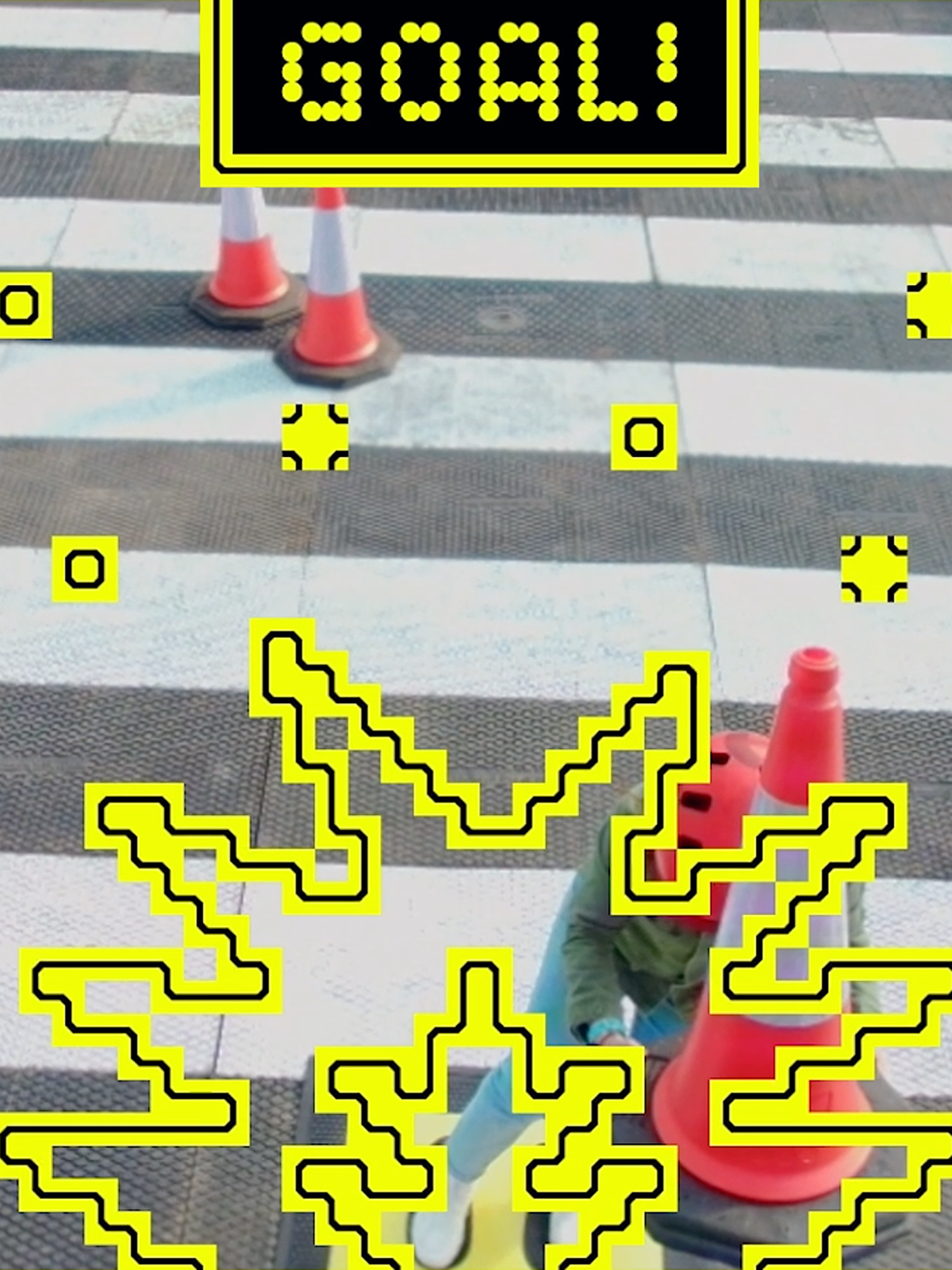 'GOAL!' text and smash iconography atop a photo of a witches cones and pedestrian crossing.