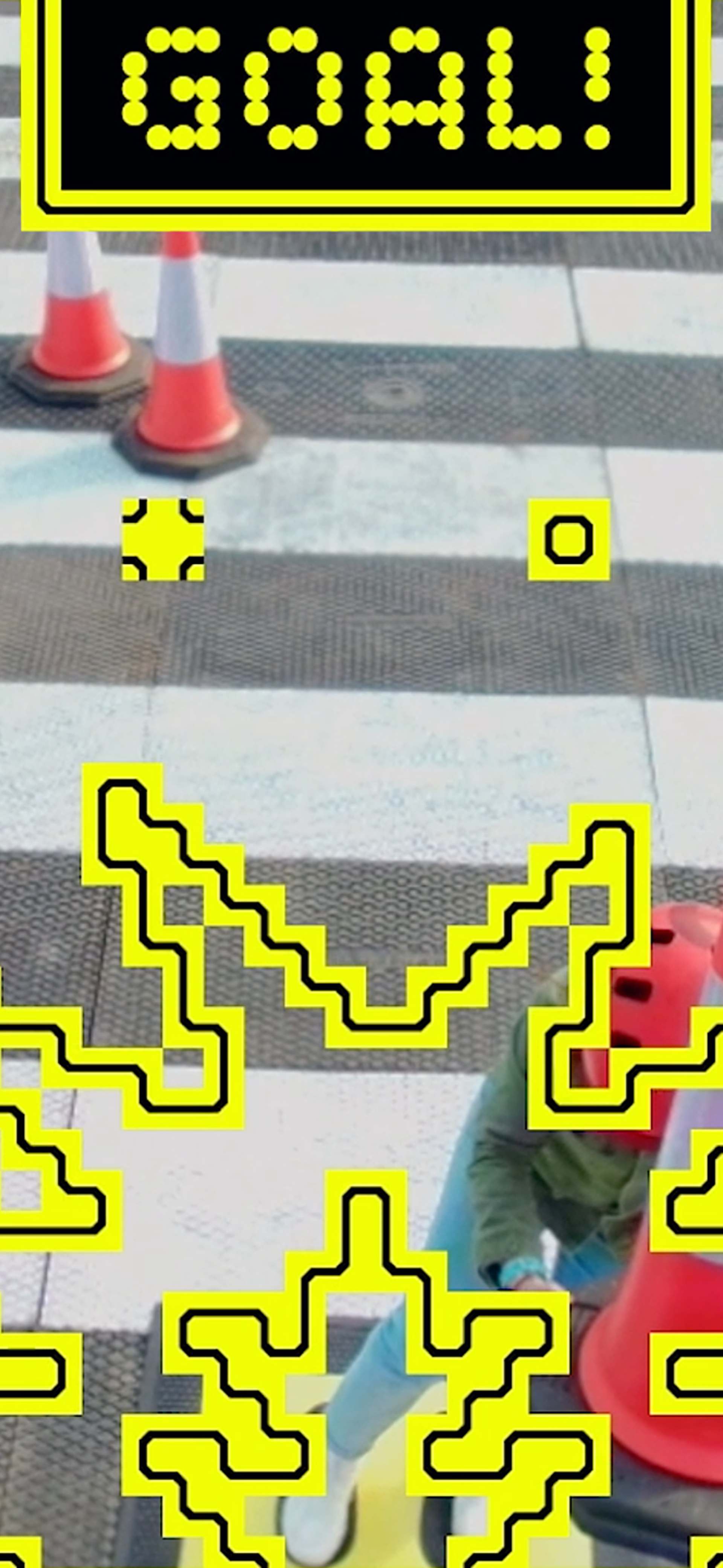 'GOAL!' text and smash iconography atop a photo of a witches cones and pedestrian crossing.