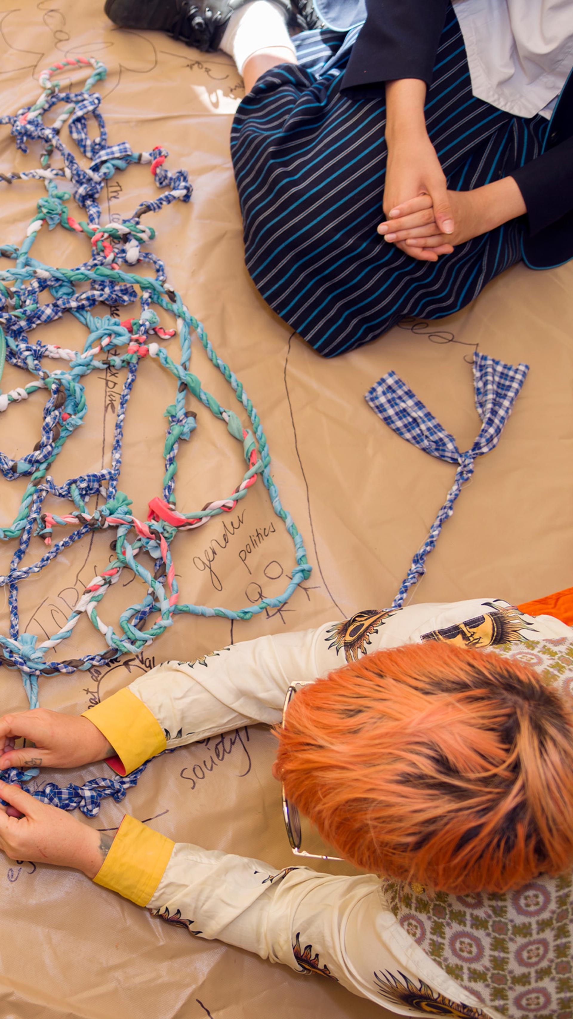 school kids sitting around a fabric workshop