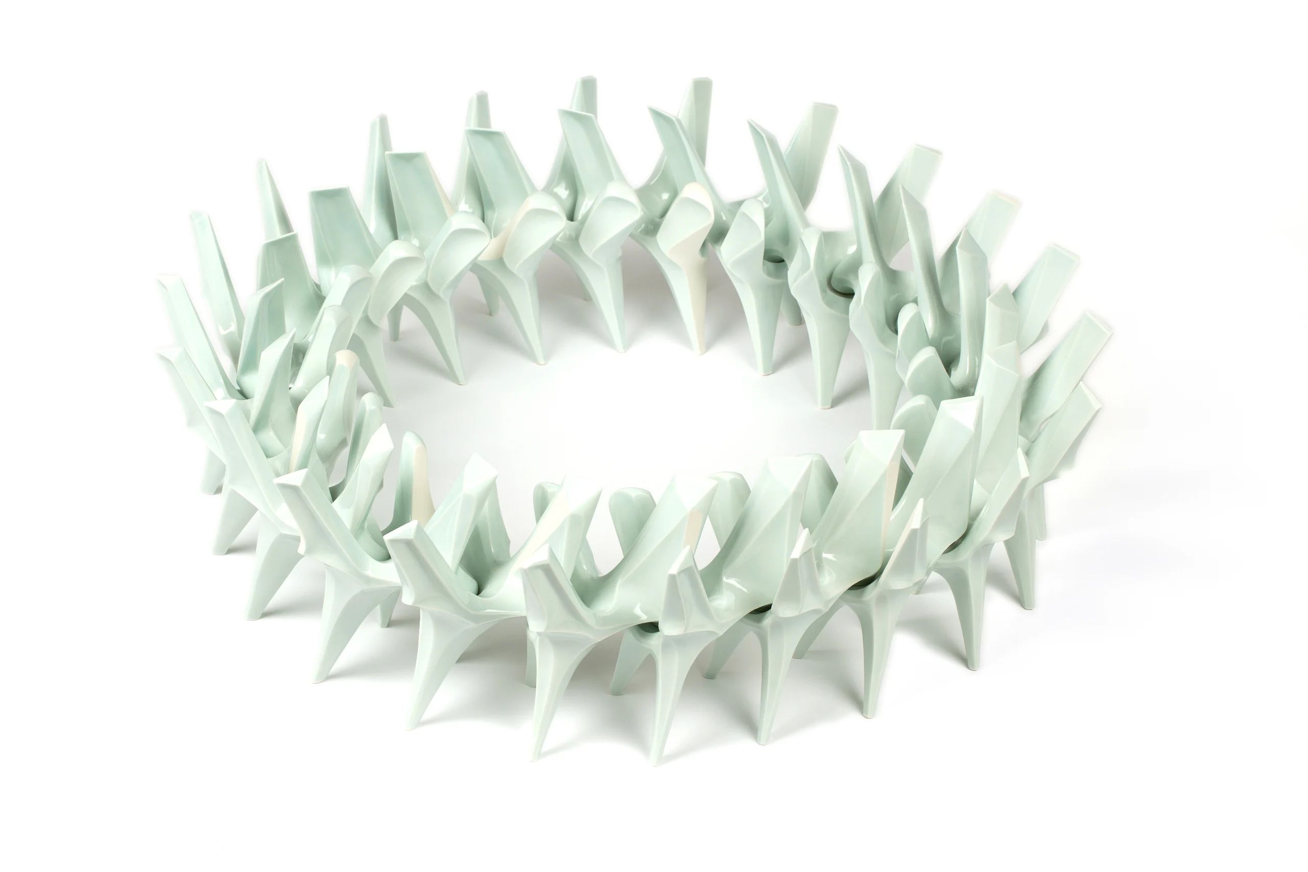 A circular installation in white slip-cast porcelain in the form of twenty-two identical interconnected pieces of organic shape.