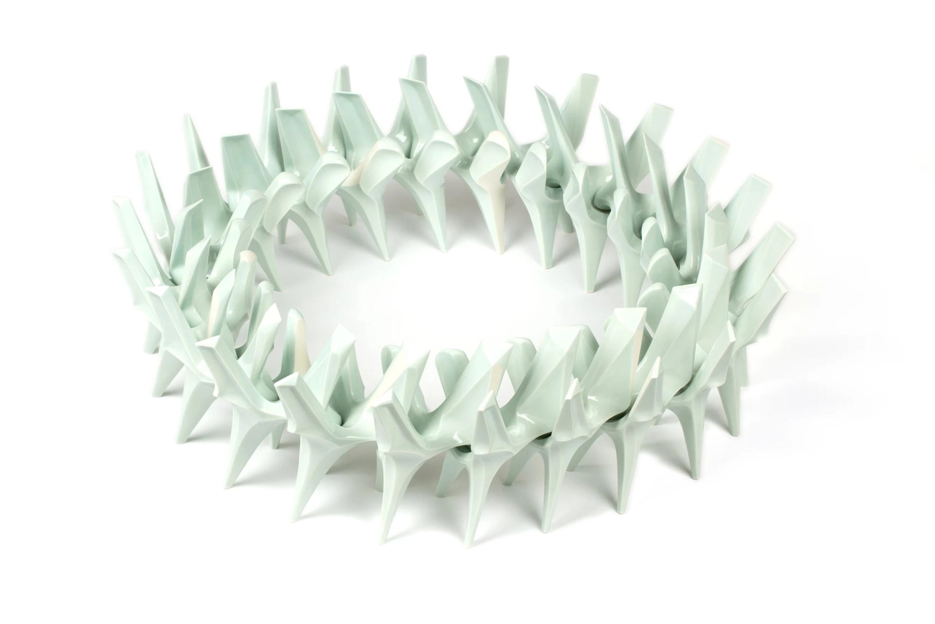 A circular installation in white slip-cast porcelain in the form of twenty-two identical interconnected pieces of organic shape.