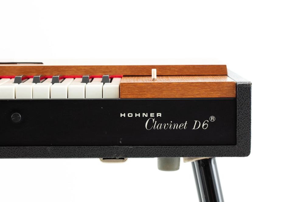 A straight on look at the edge of the Hohner Clavinet D6 showing the top end of the keyboard, the logo text, and small switch.