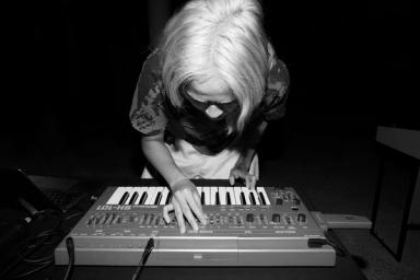 Black and white image of Corin bent over a keyboard.