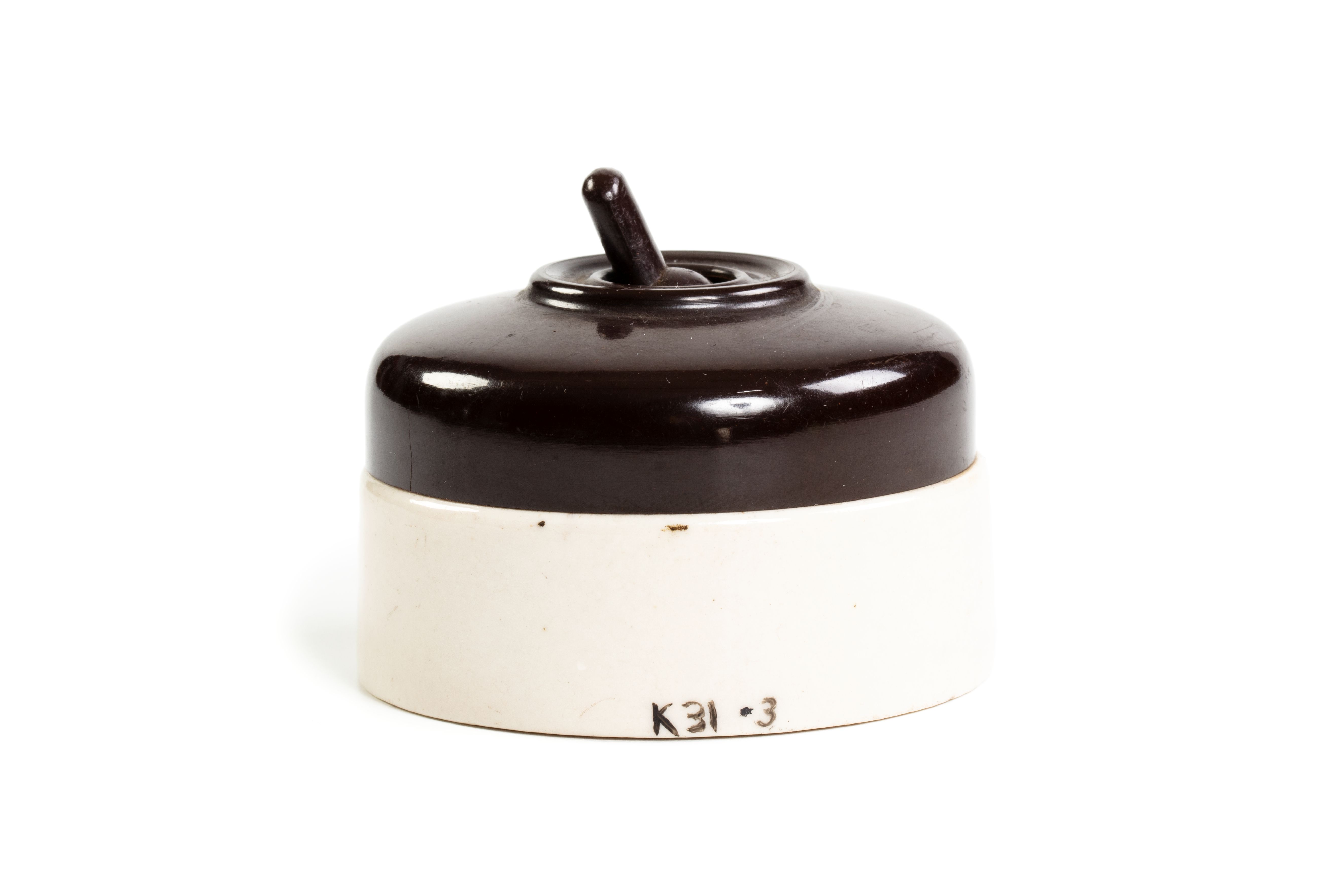 Image of a light switch, a porcelain made light switch with a dark brown lever switch and white base.
