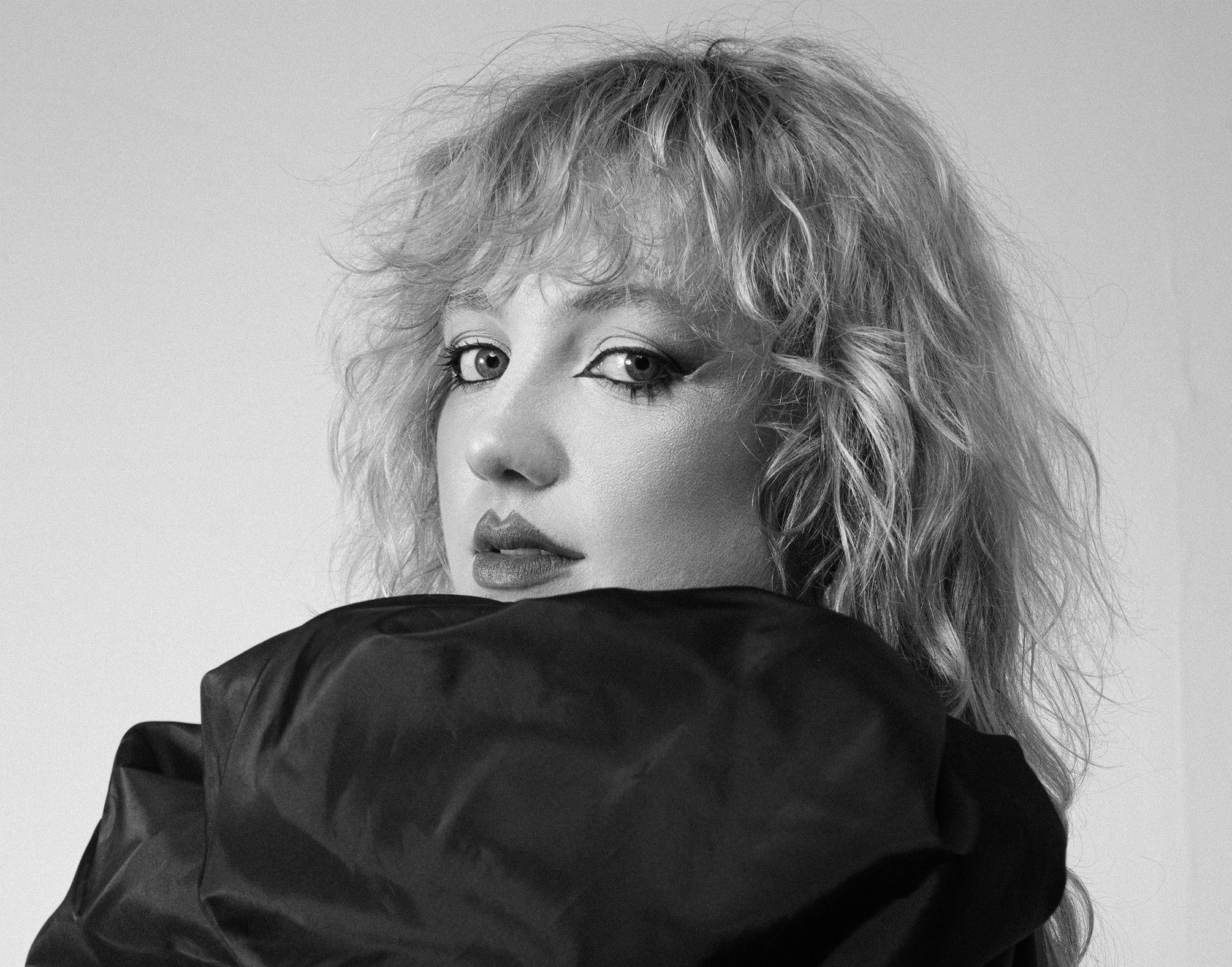 Figure holding their body wearing makeup.