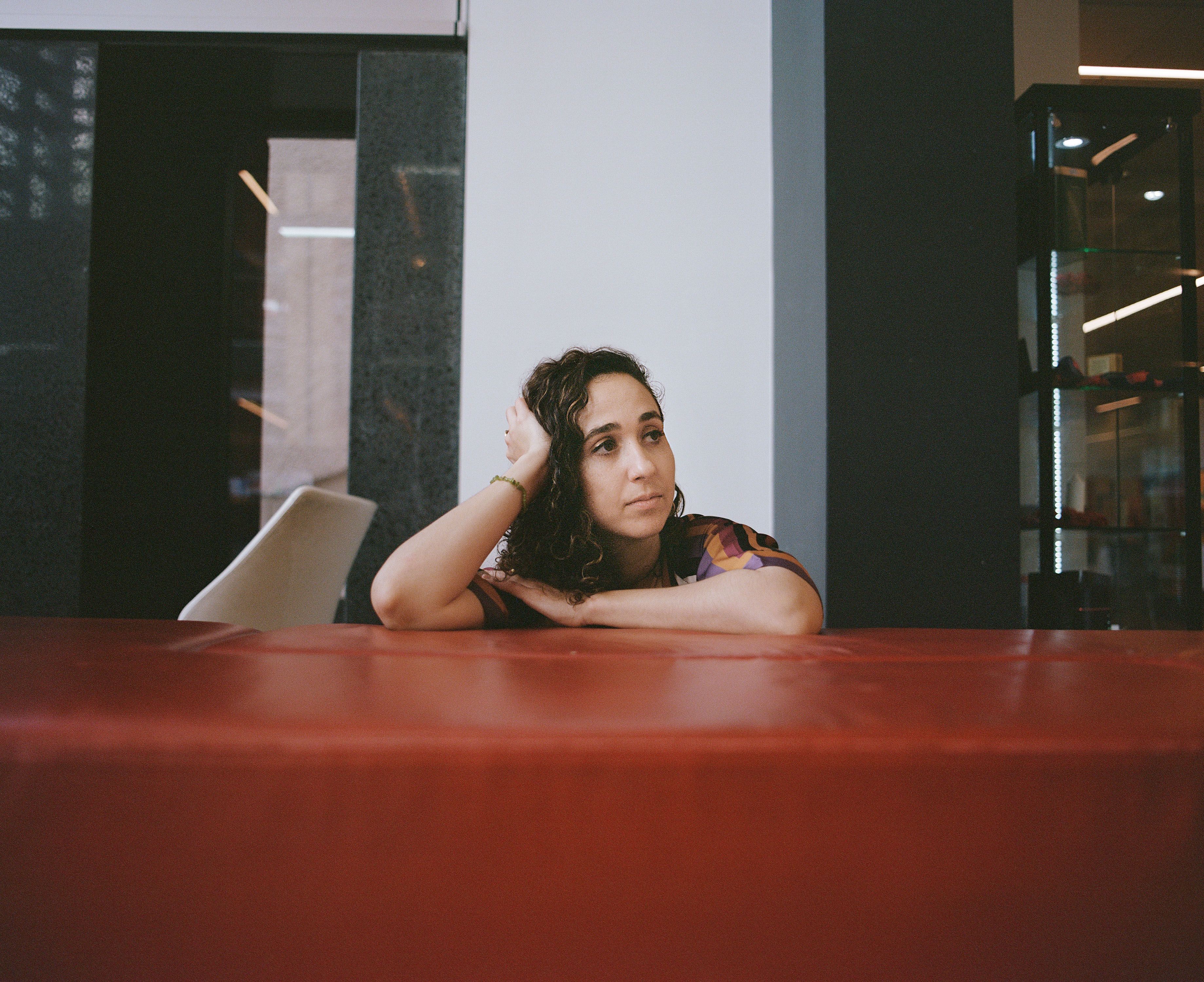 Figure leans on a wall, and looks out of frame.