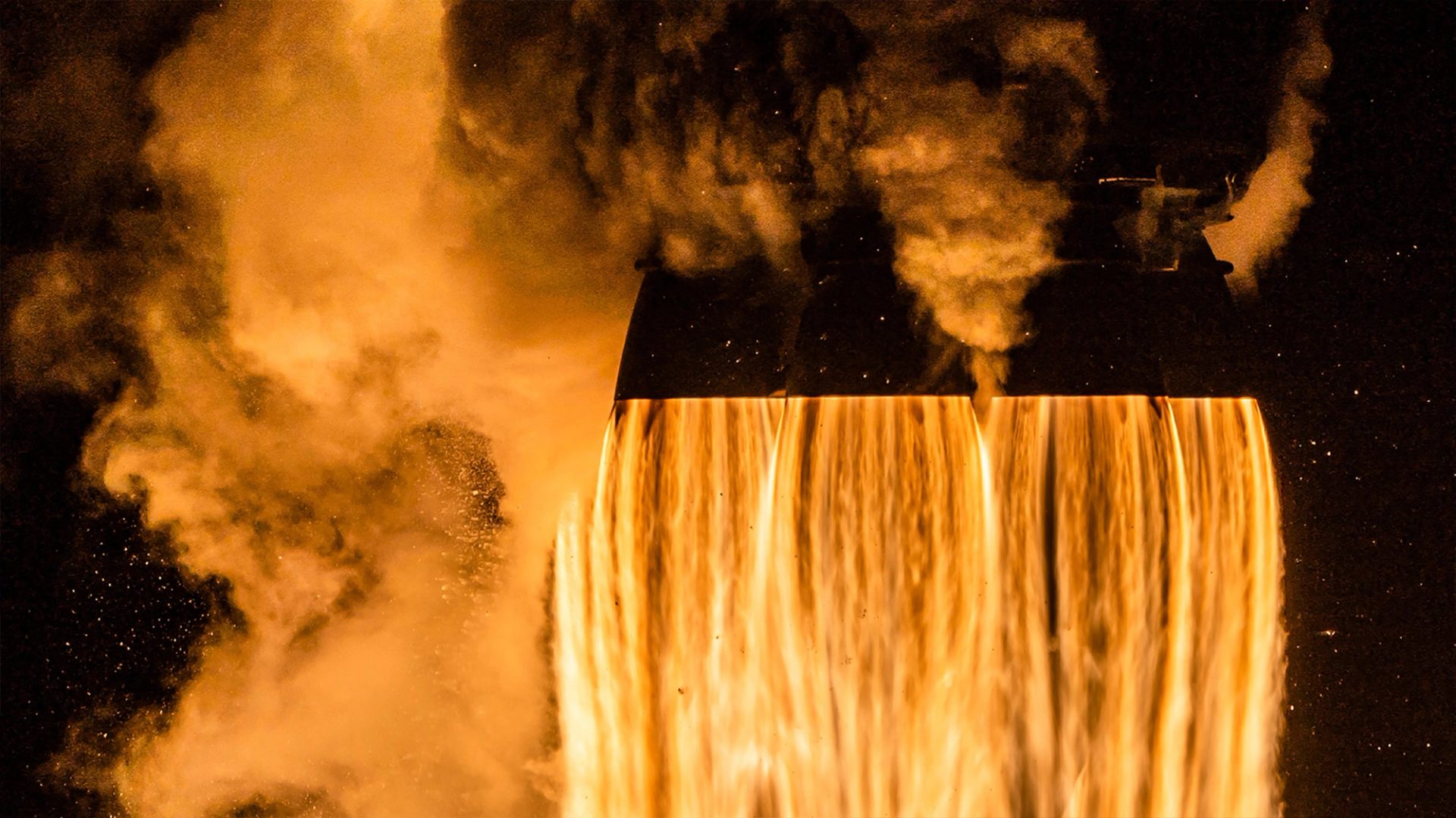 Close up of the bottom of the Crew-4 spacecraft launching, fire and smoke coming out of the 4 cone shaped exhausts and filling the image.