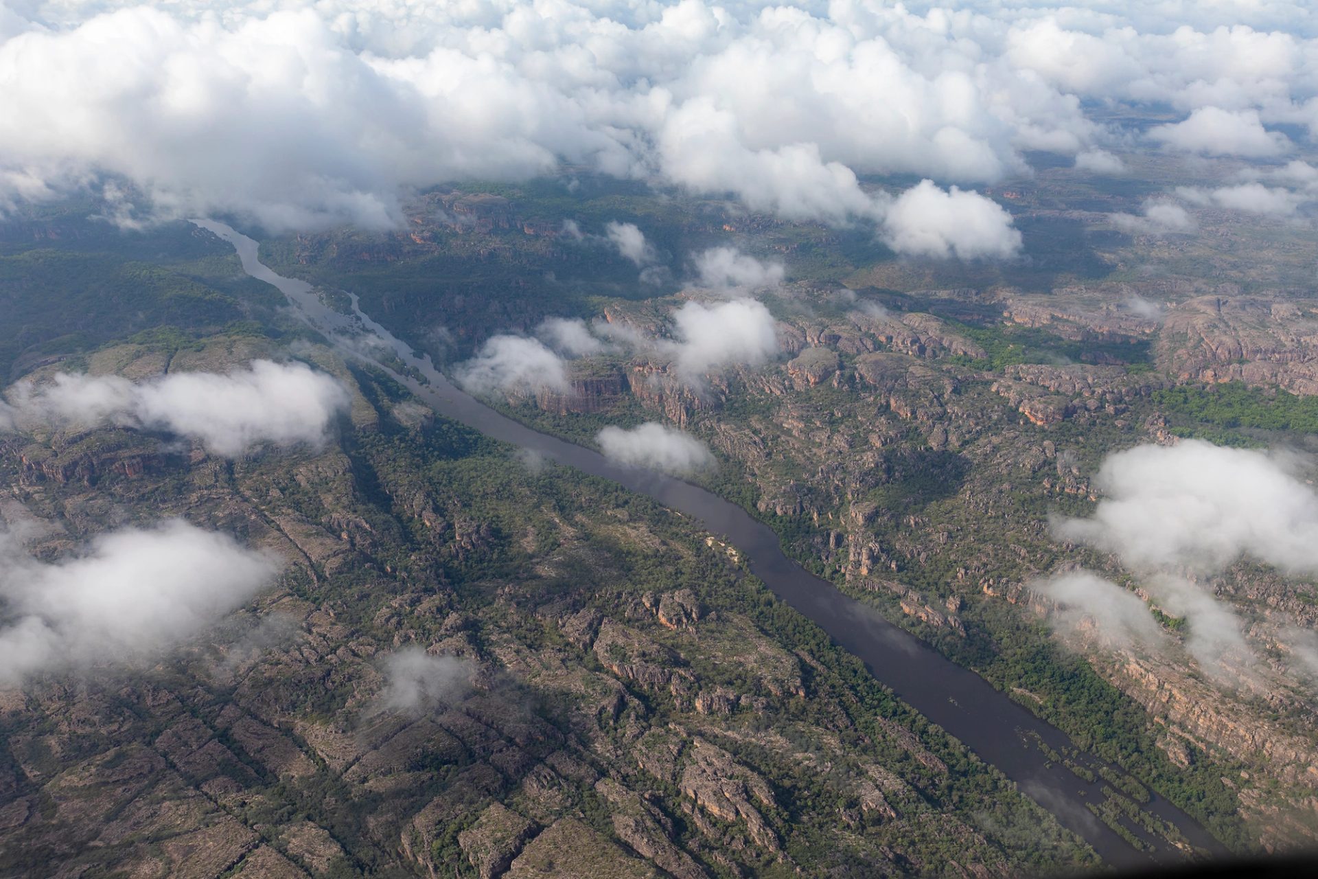 An aerial view of a green and rocky landscape with a river running through it.