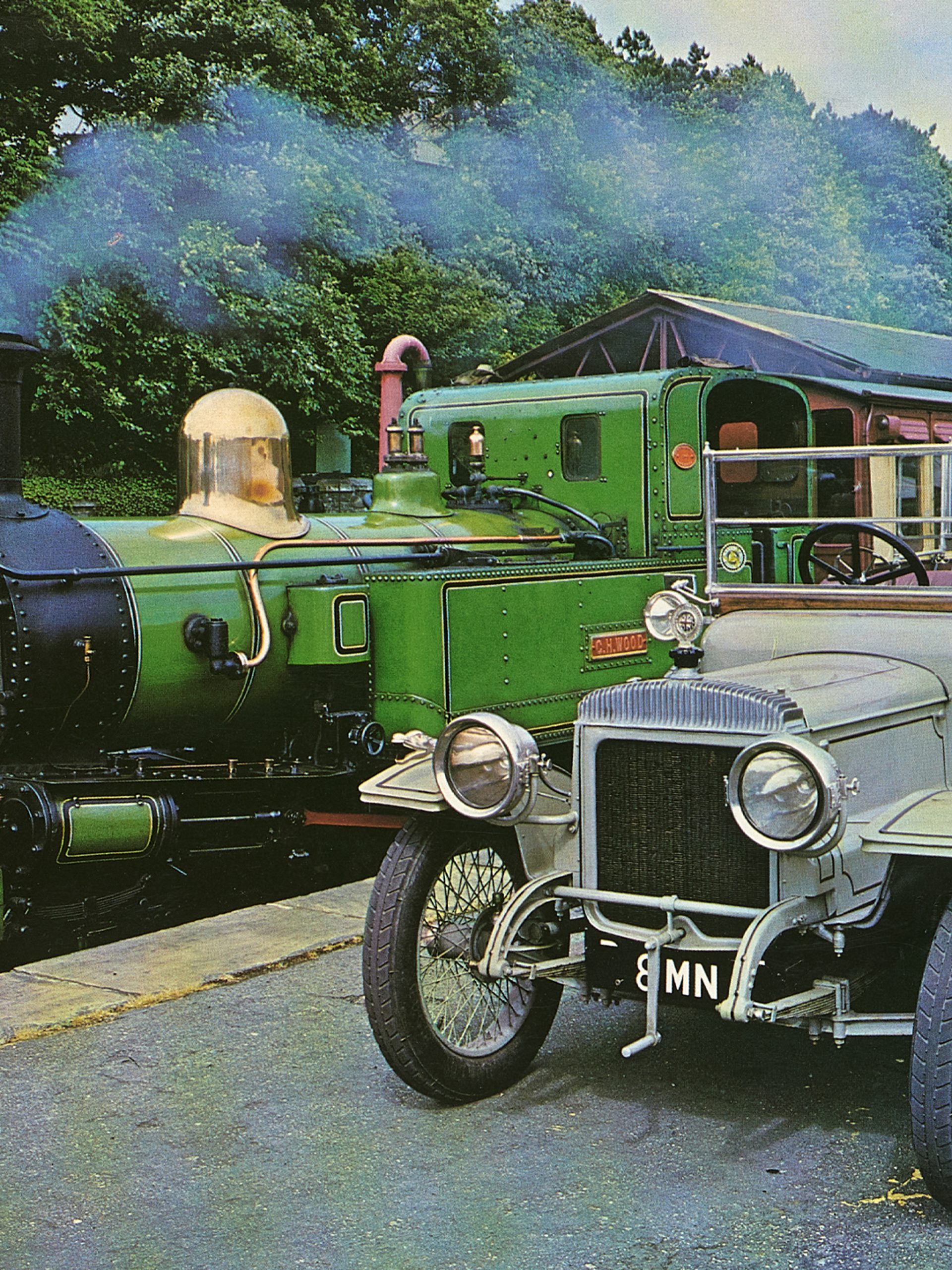Colour photographic print of a 1914 Daimler and train, cut from calendar or magazine.