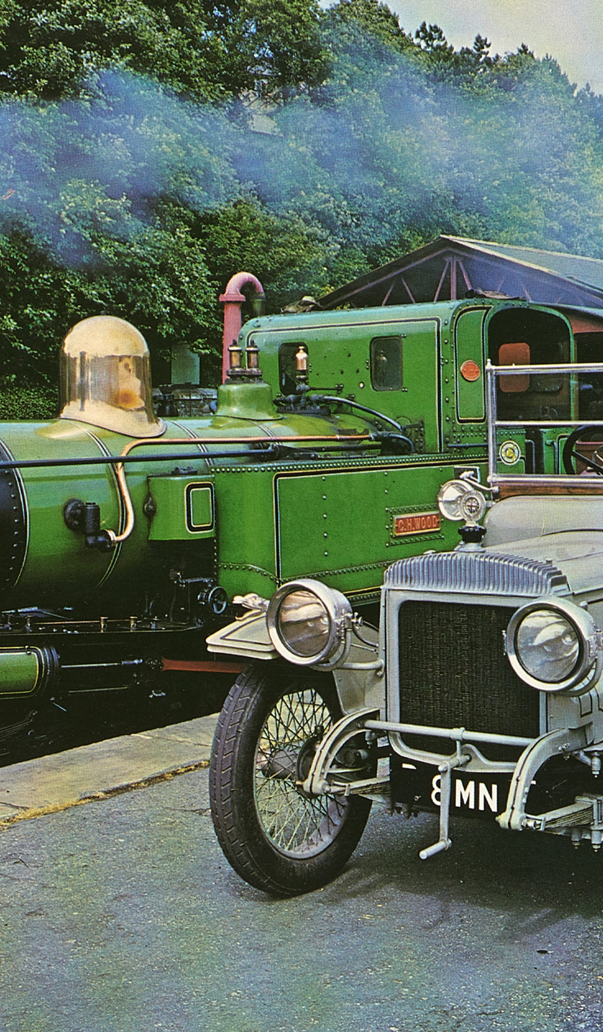 Colour photographic print of a 1914 Daimler and train, cut from calendar or magazine.