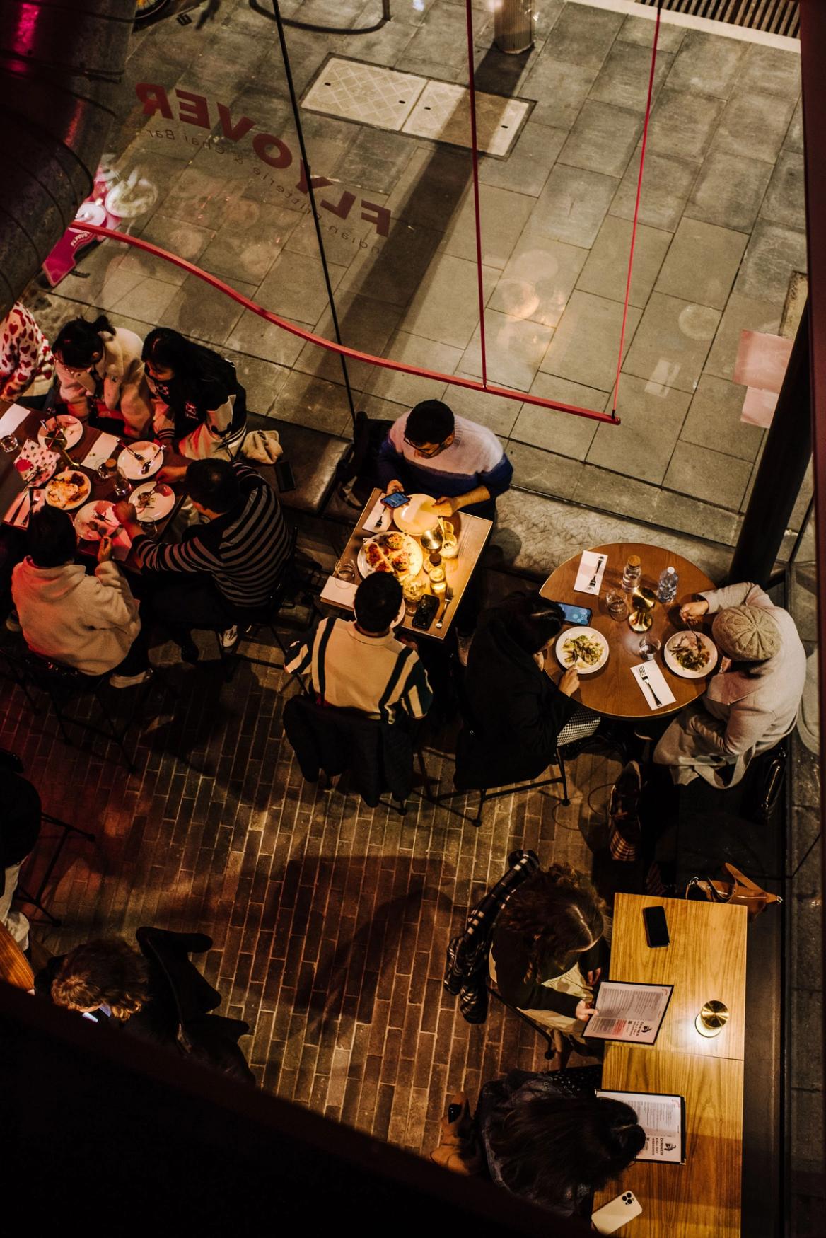 An overhead view of patrons dining inside "Flyover Indian Fritterie & Chai Bar”.