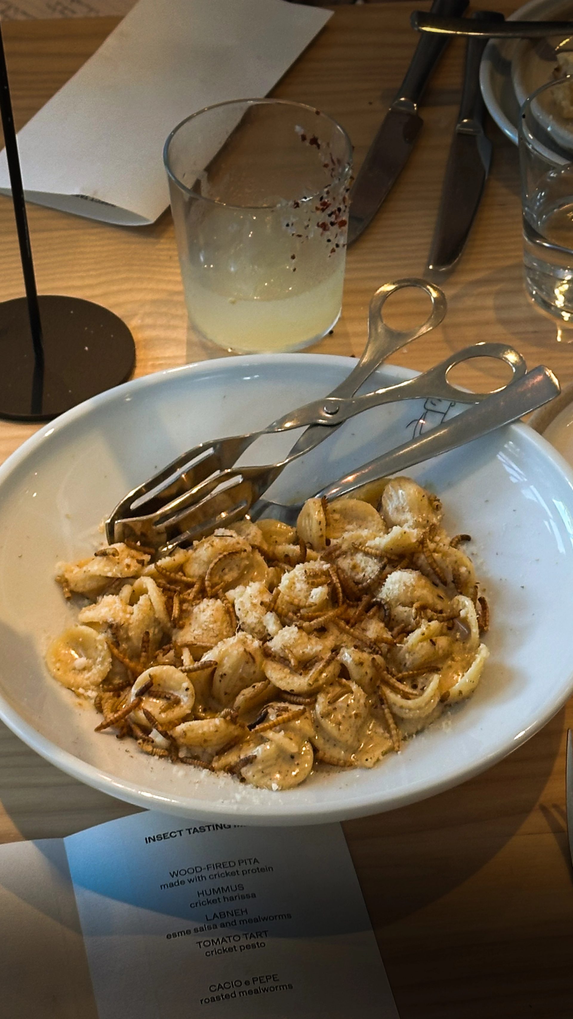 Pasta dish with grubs and servers.